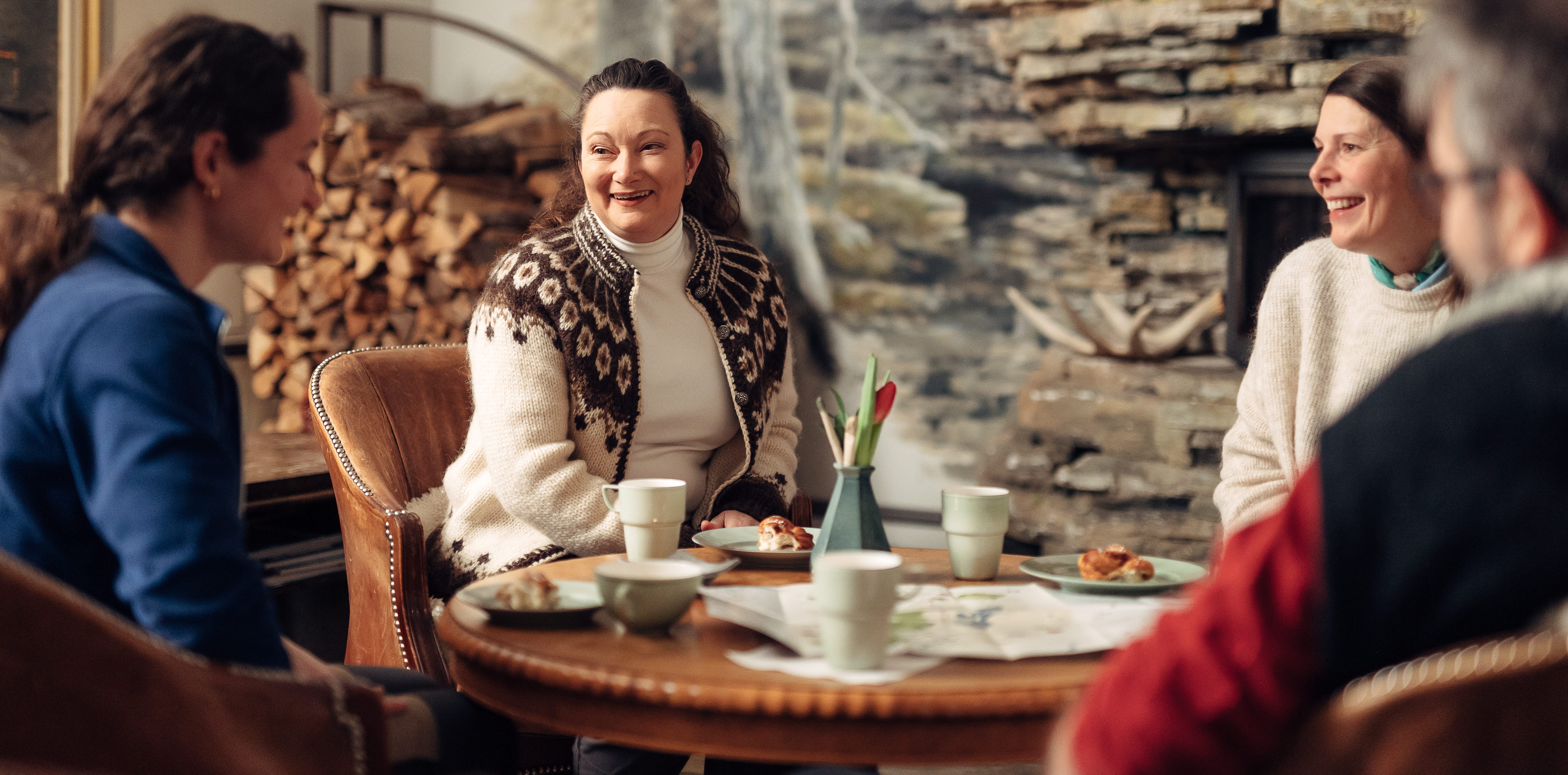 Grupp av människor njuter av en fika hos Löfwings Ateljé & Krog.