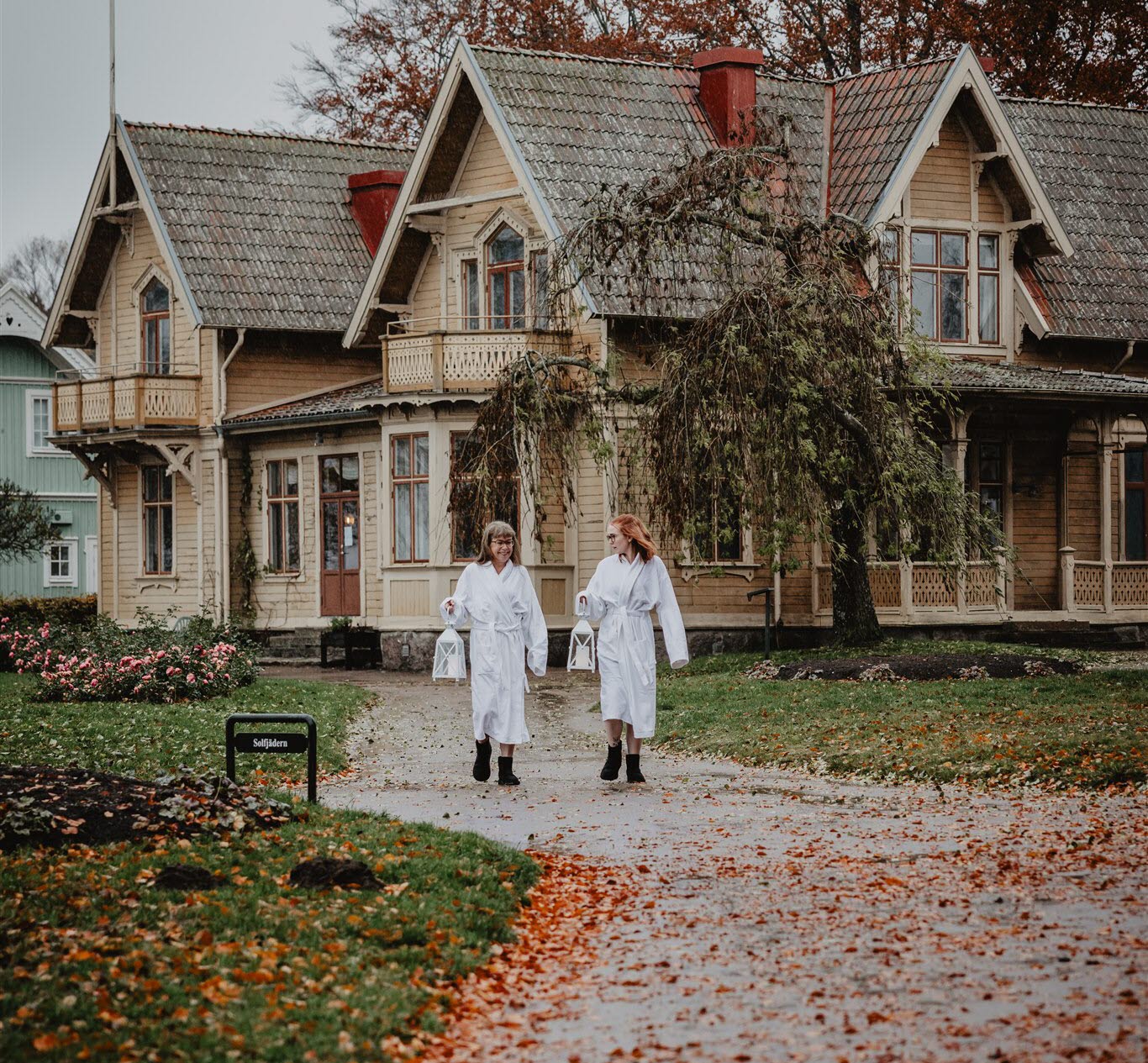 Kvinnor umgås klädda i badrockar.