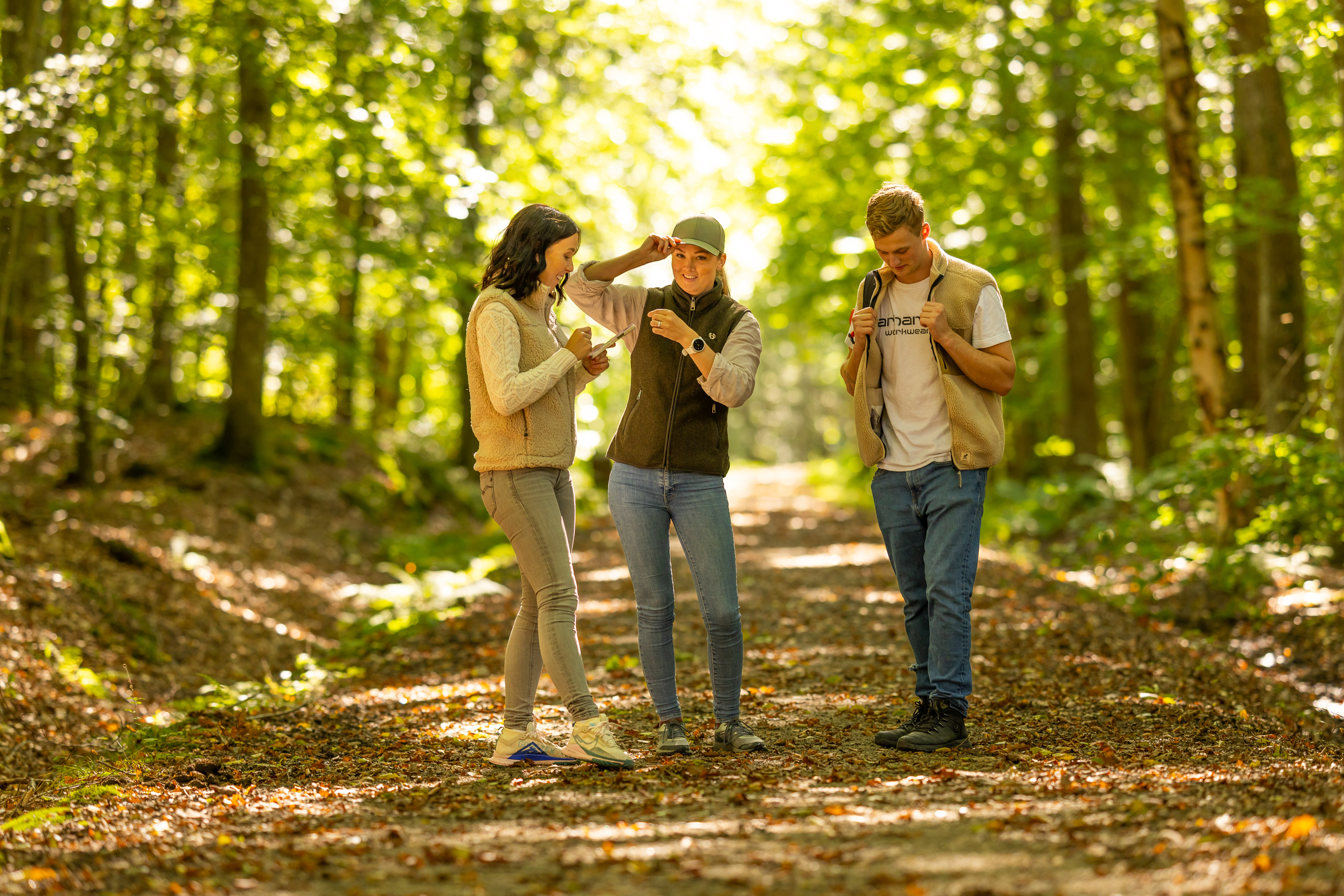 Tre personer vandrar på en grusväg.