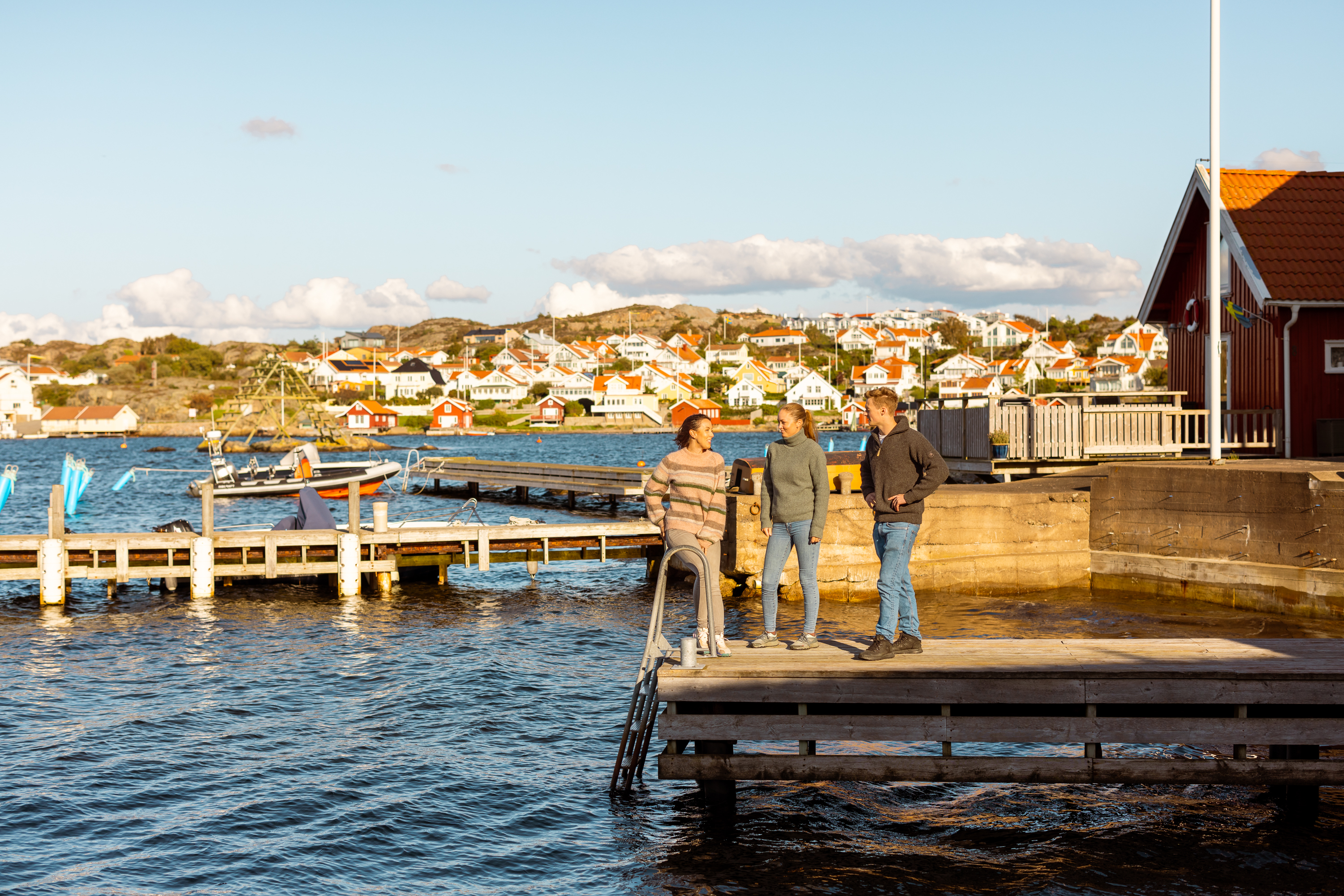 Friends sitting on a wooden jetty.