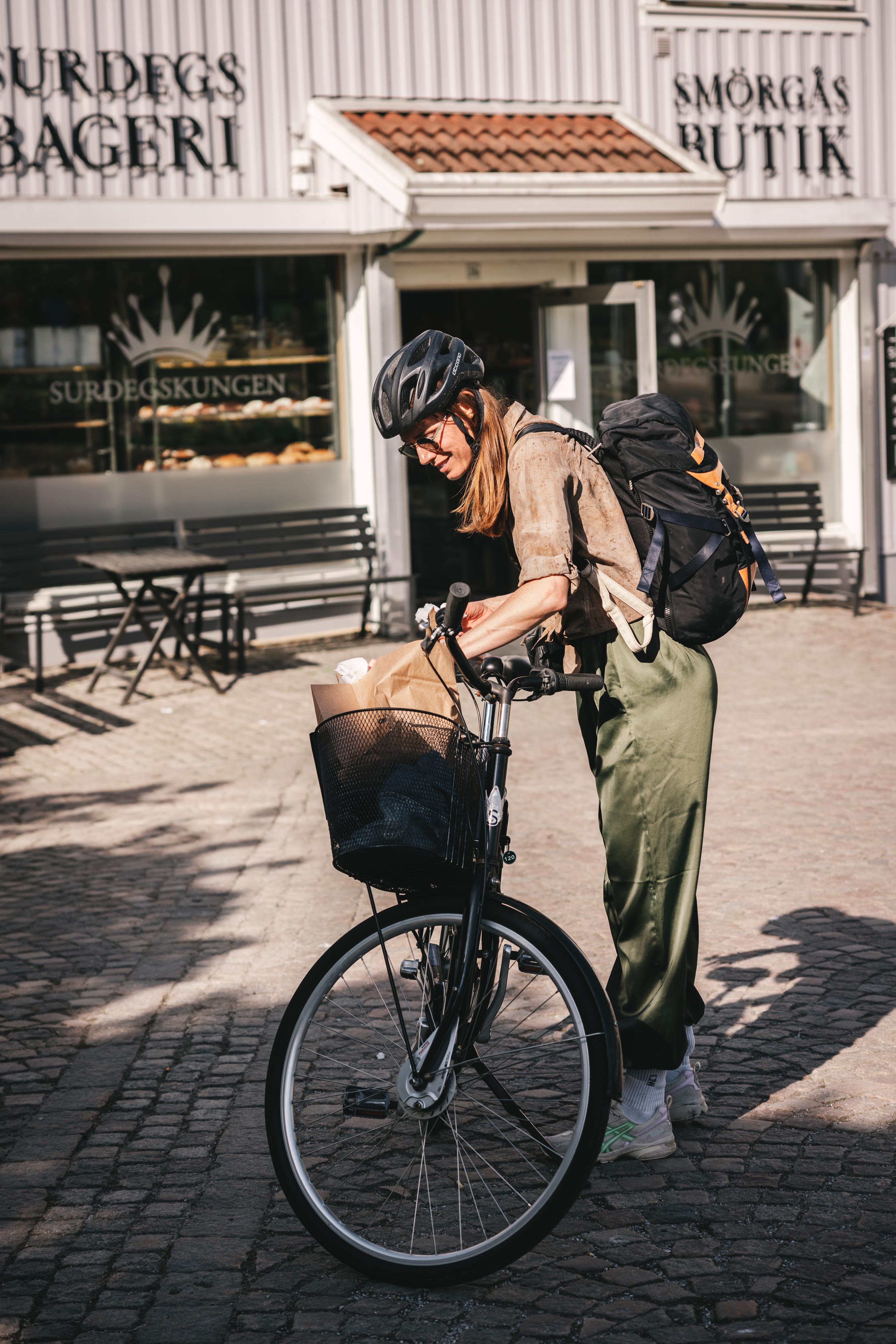 Kvinna vid en cykel som har handlat surdegsbakade bullar.