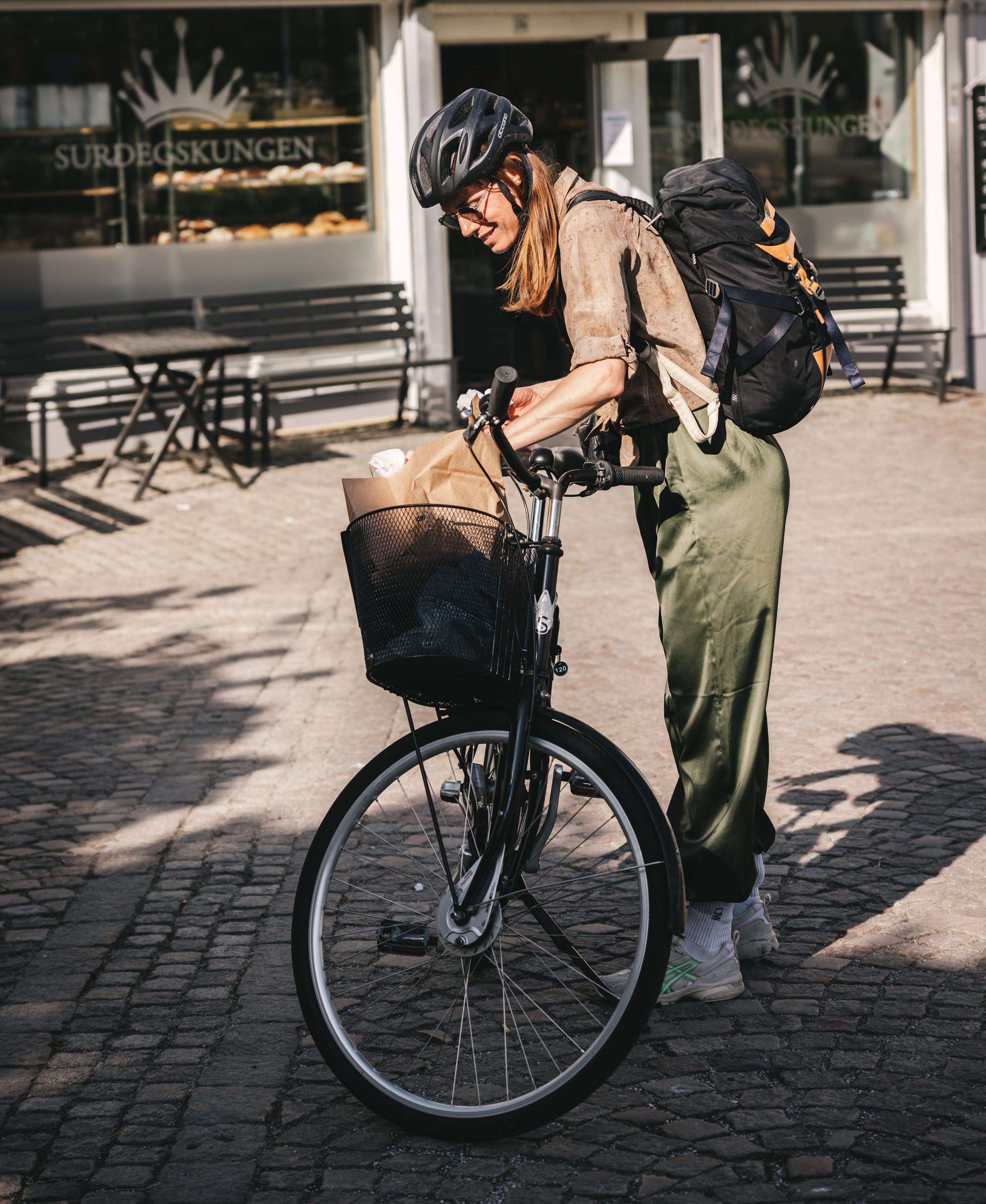 Woman by a bicycle who has bought sourdough buns.