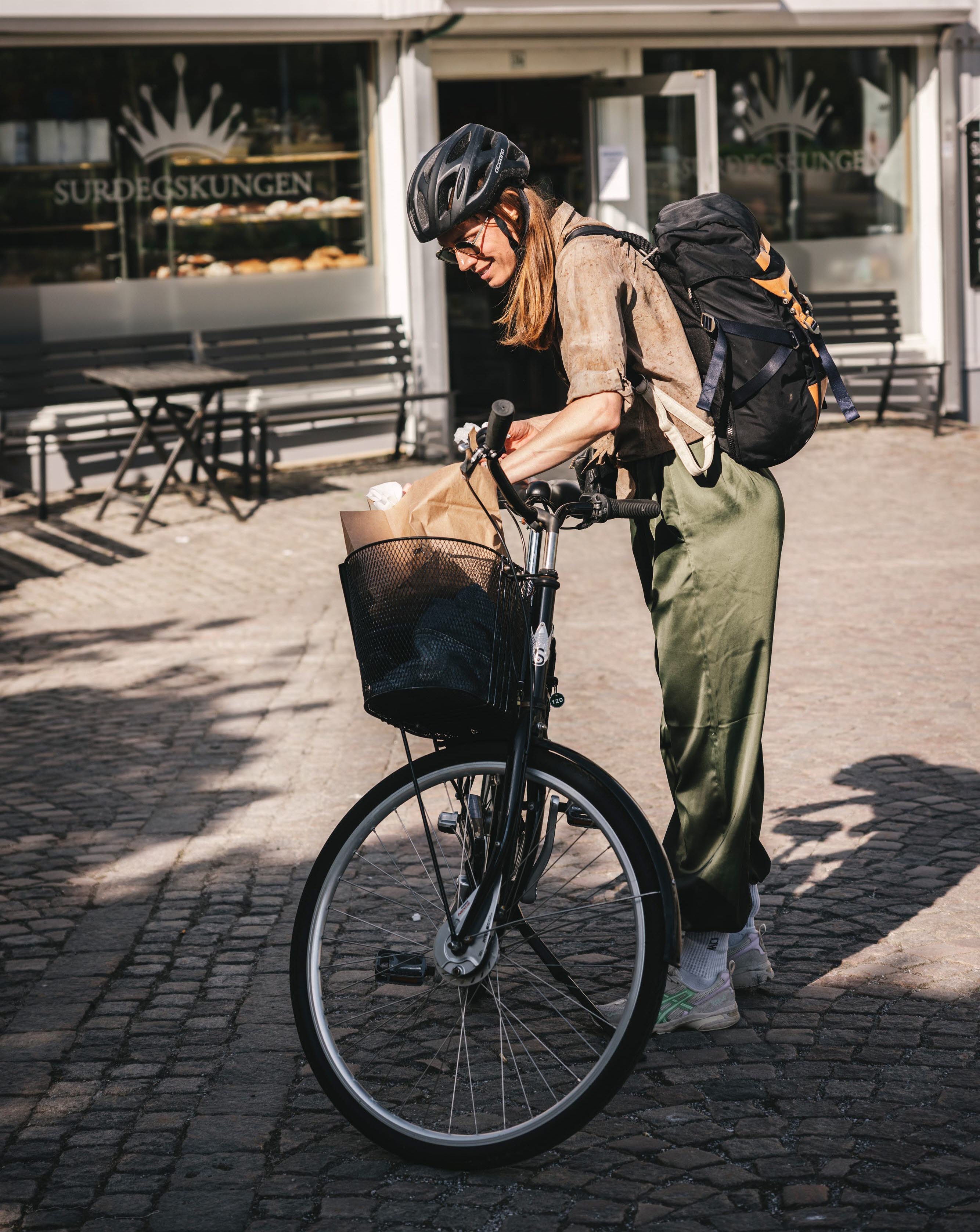 Kvinna vid en cykel som har handlat surdegsbakade bullar.