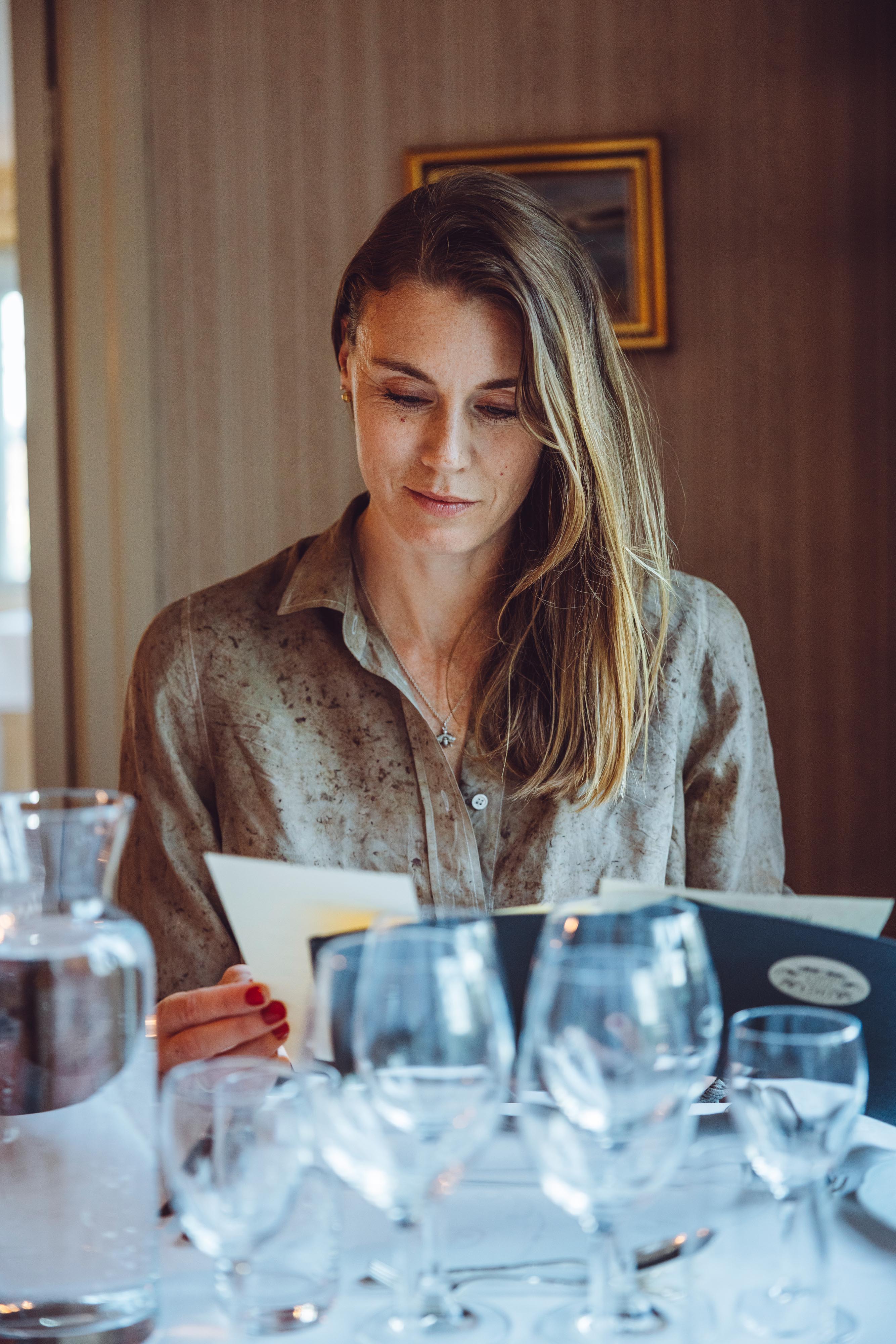 Woman reading a menu at Tofta Herrgård.