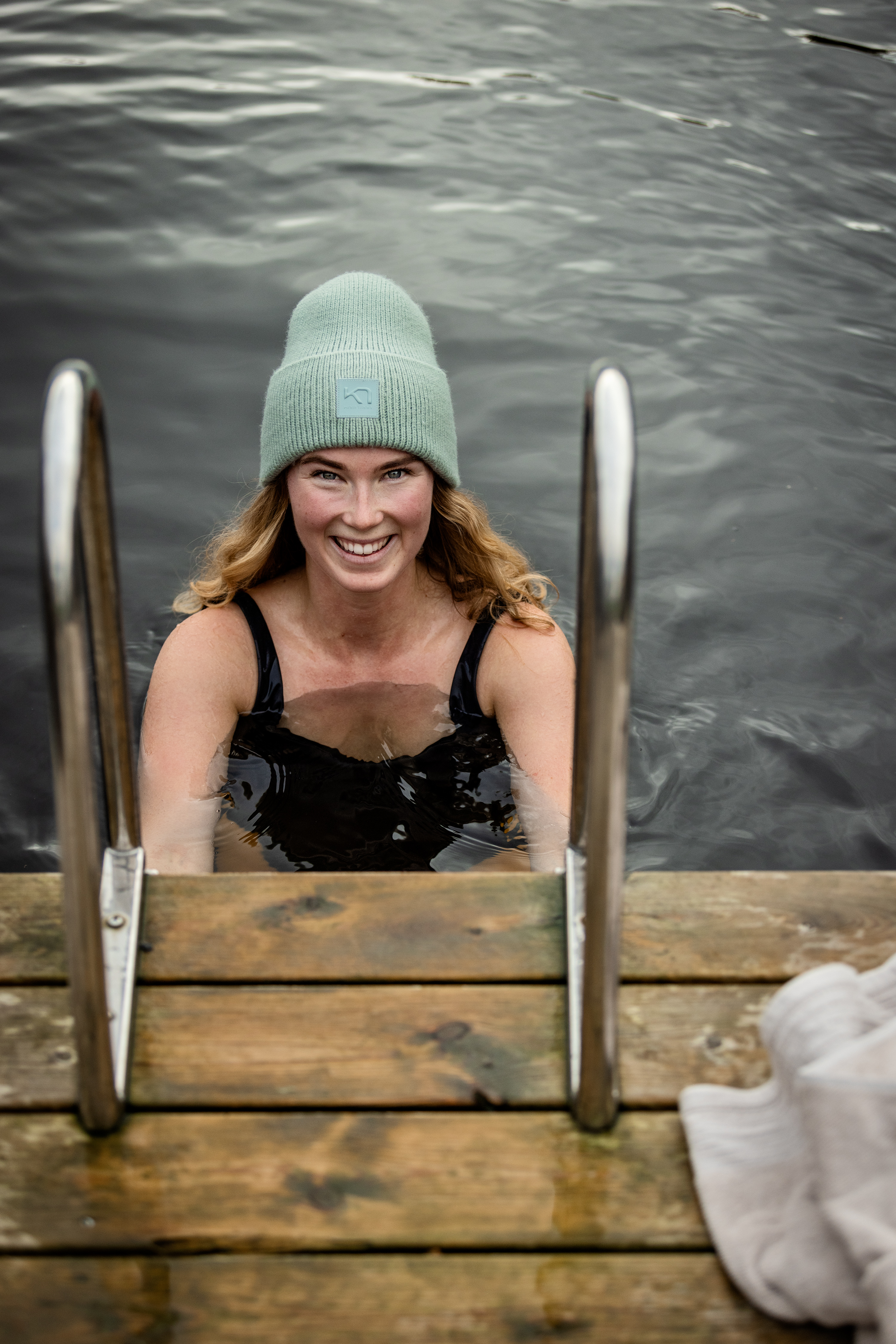Woman with cap taking a dip in a lake.