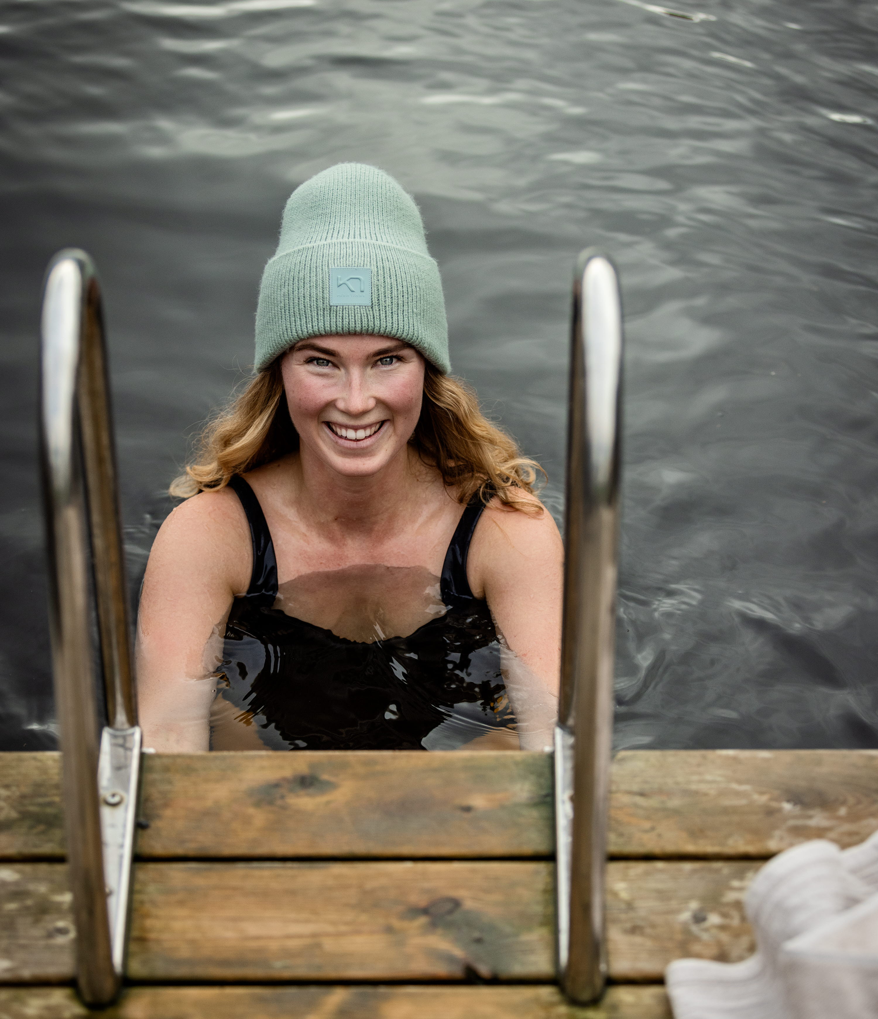 Woman with cap taking a dip in a lake.