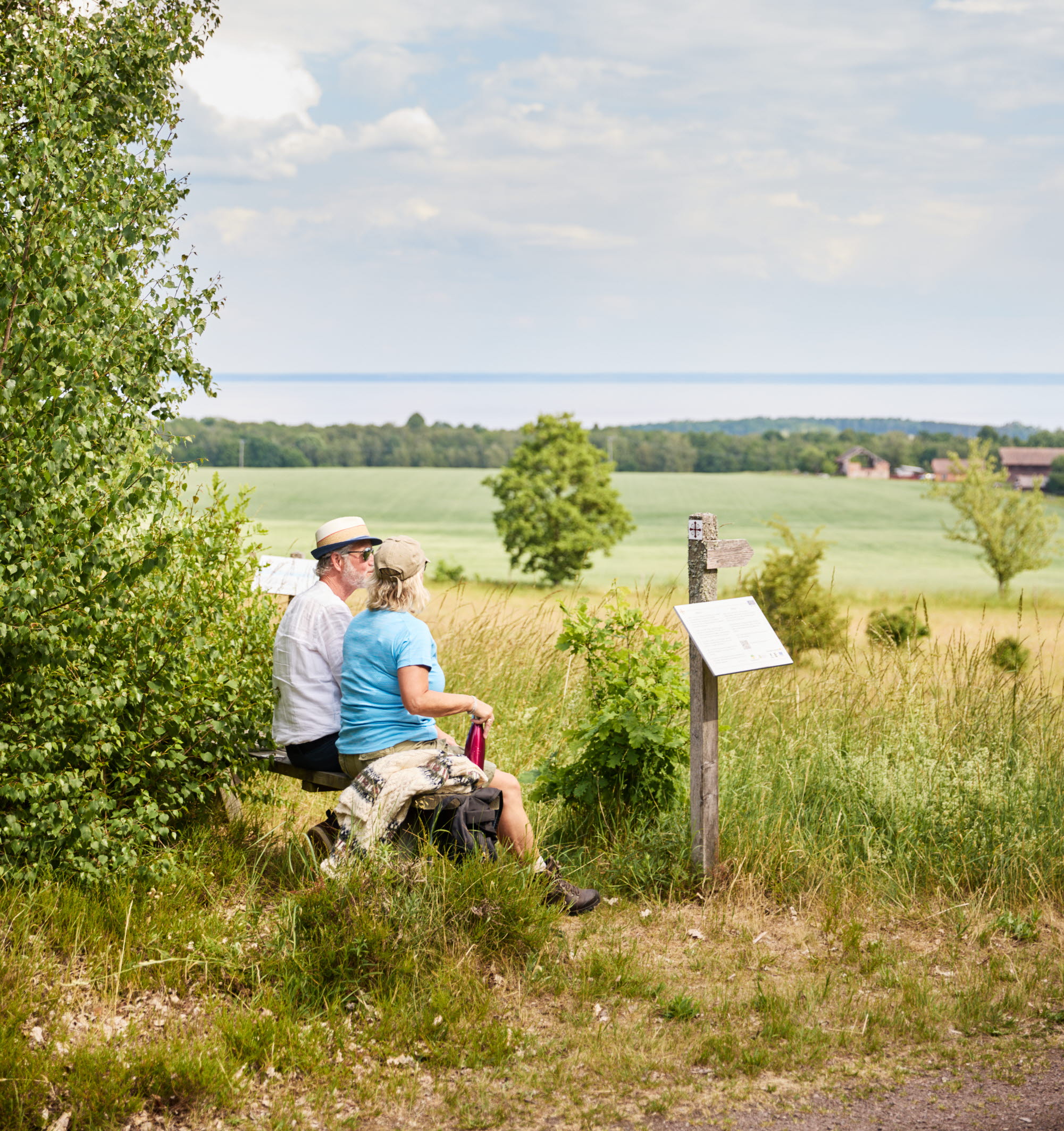 Två personer sitter på en bänk och vilar.