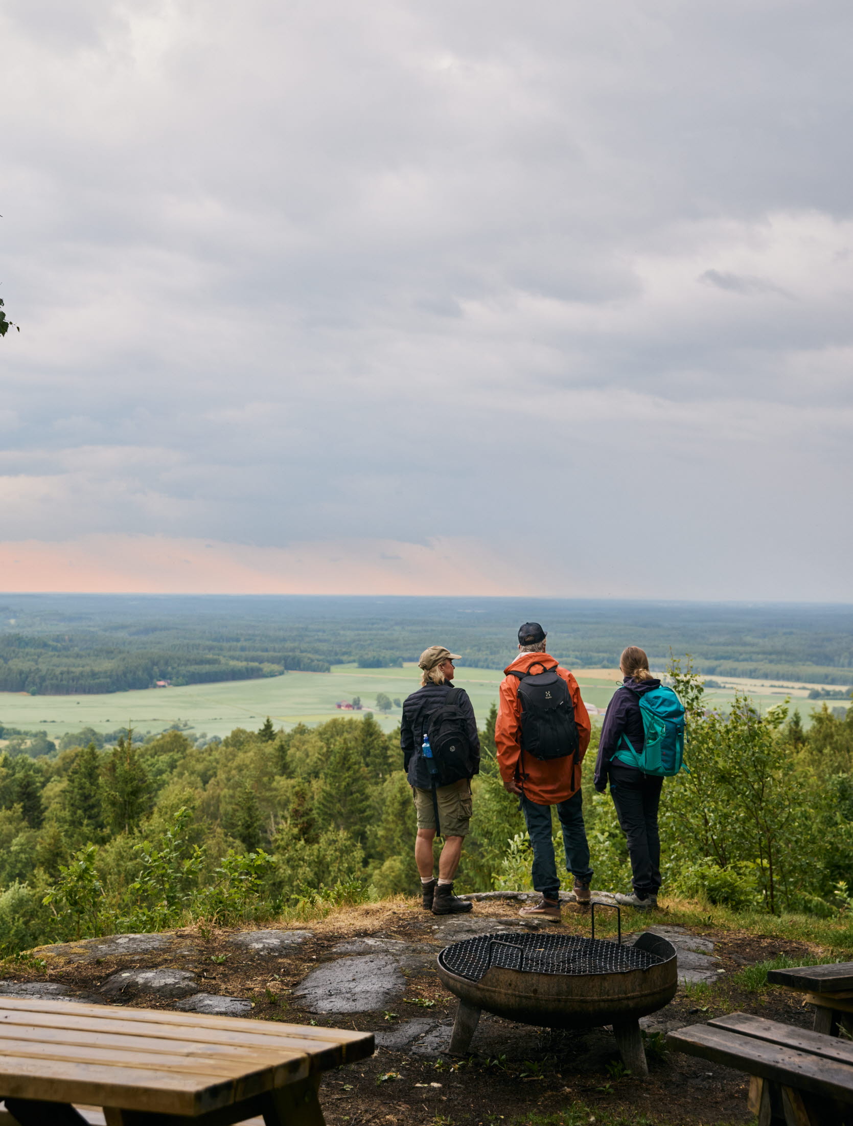 Människor står vid en utsiktsplats och tittar ut över landskap.