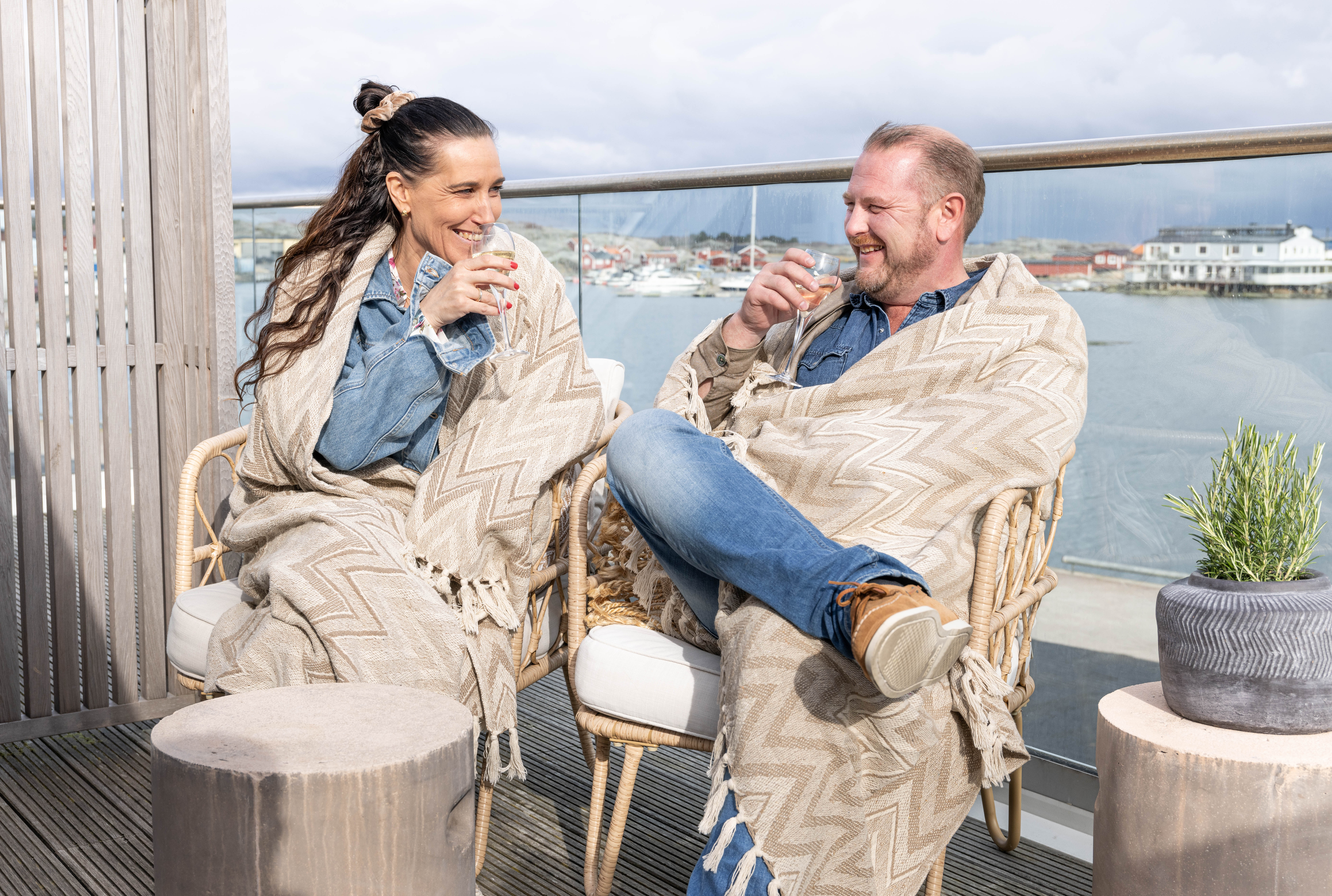 Man and woman on a balcony in an archipelago environment.