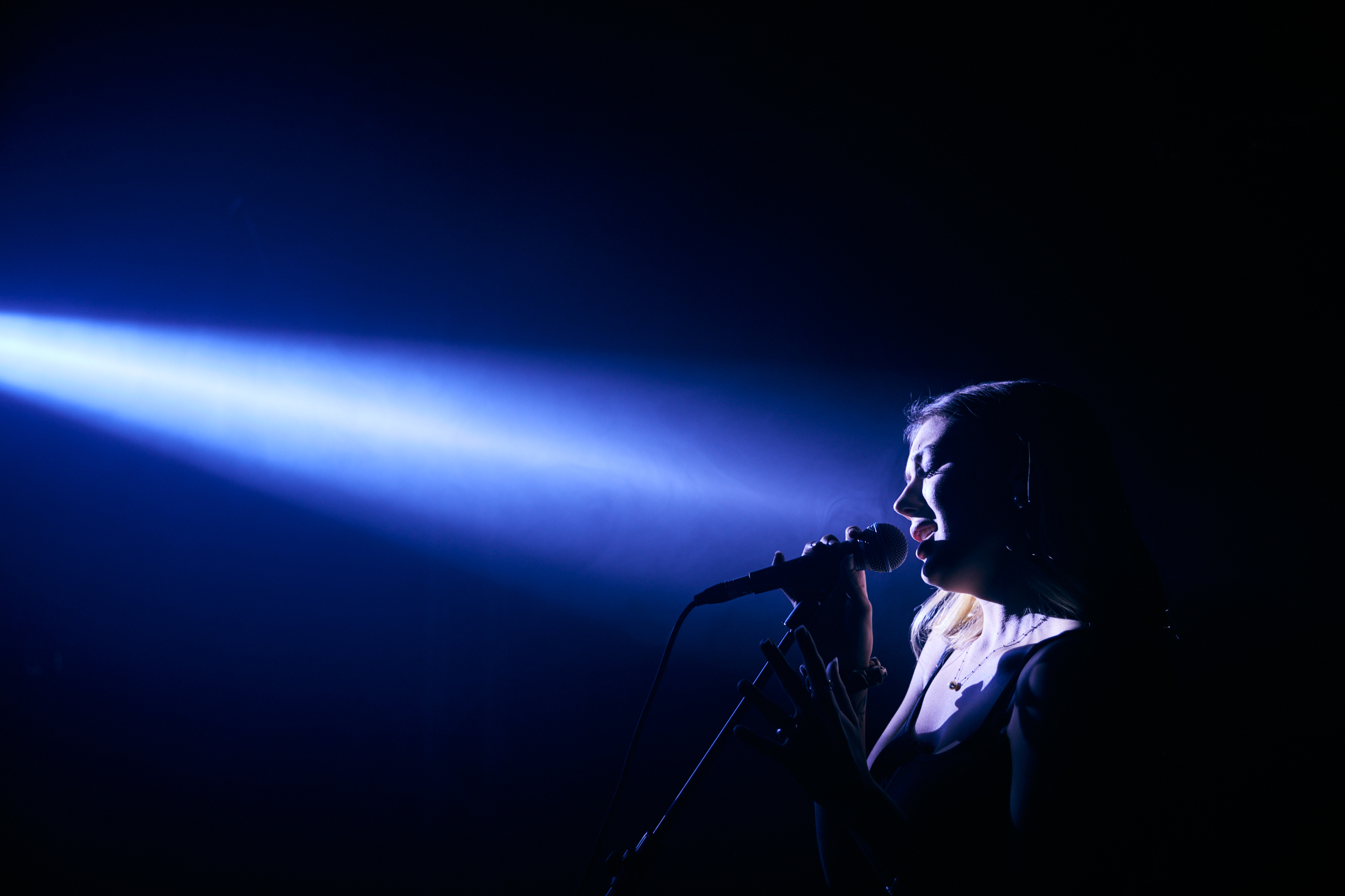 Kvinna sjunger på musikscen.
