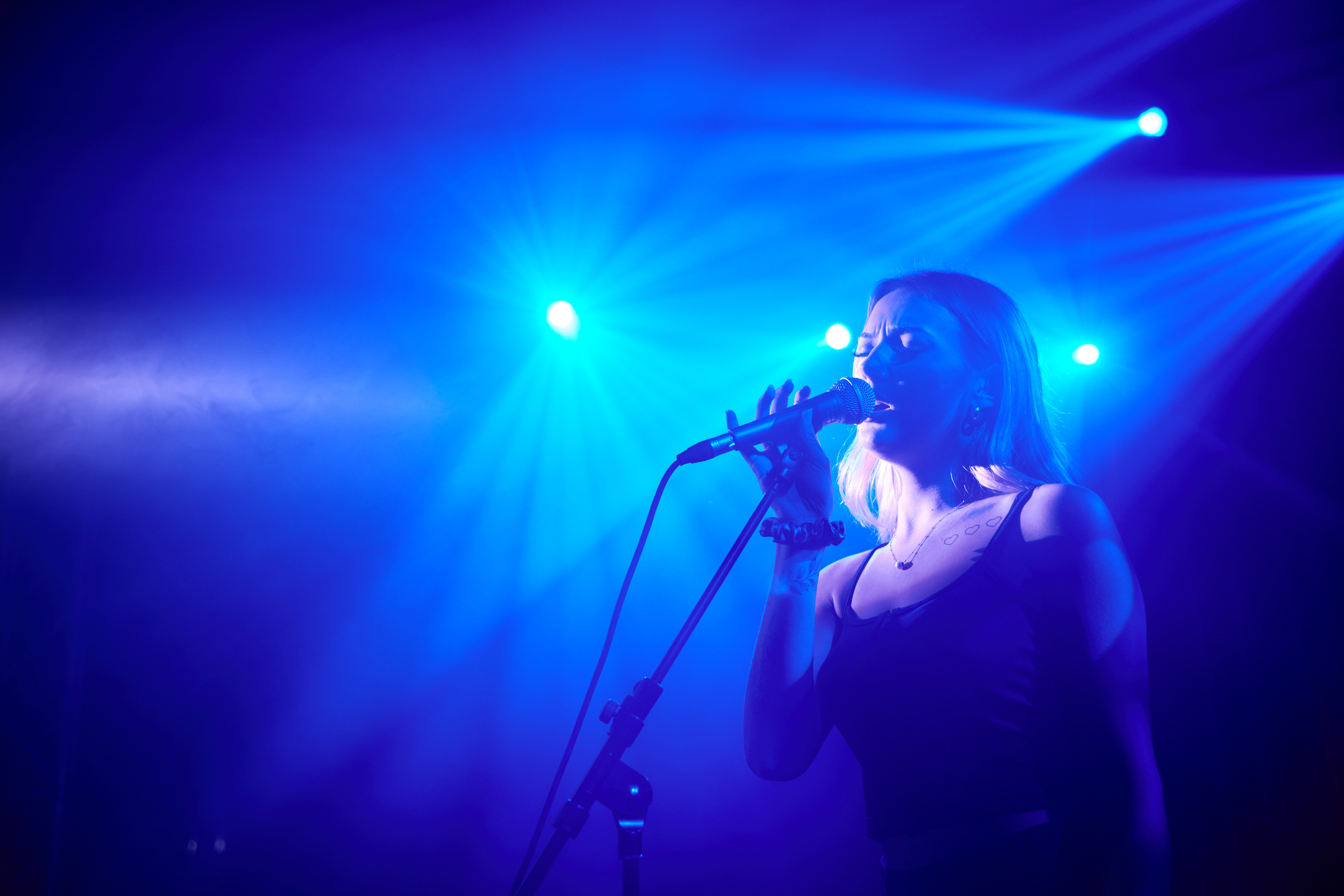 Kvinna sjunger på musikscen.