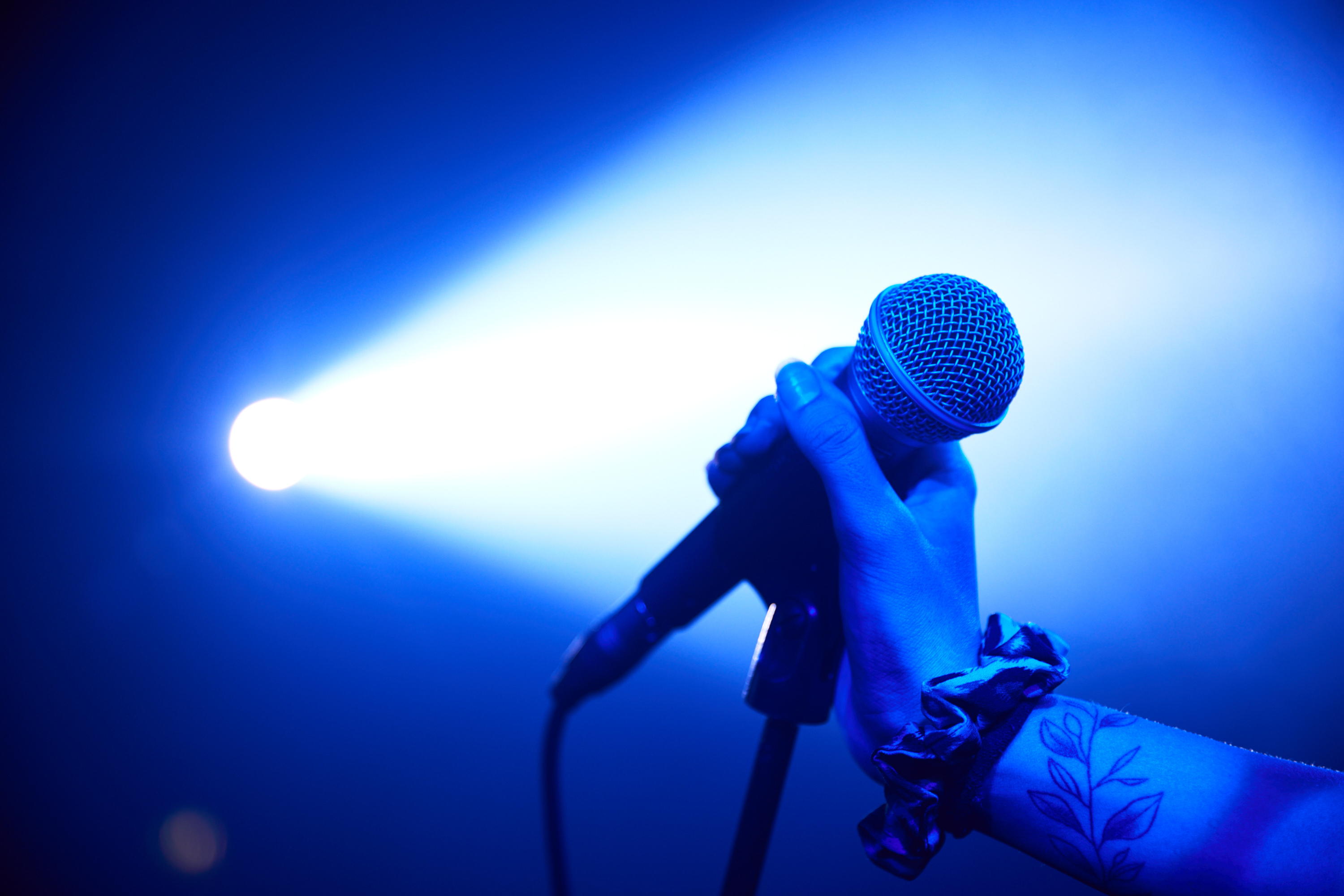 Kvinna sjunger på musikscen.