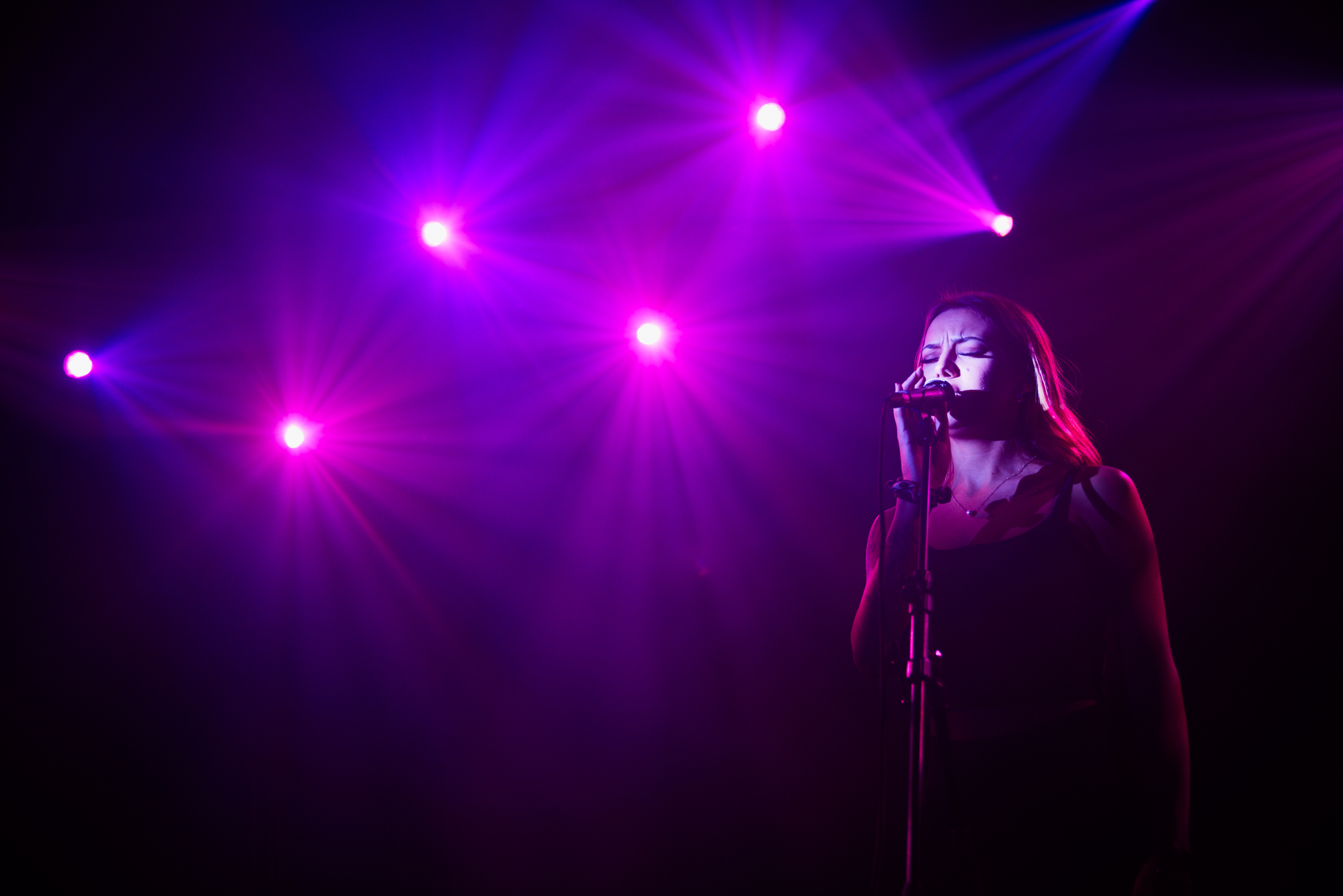 Kvinna sjunger på musikscen.