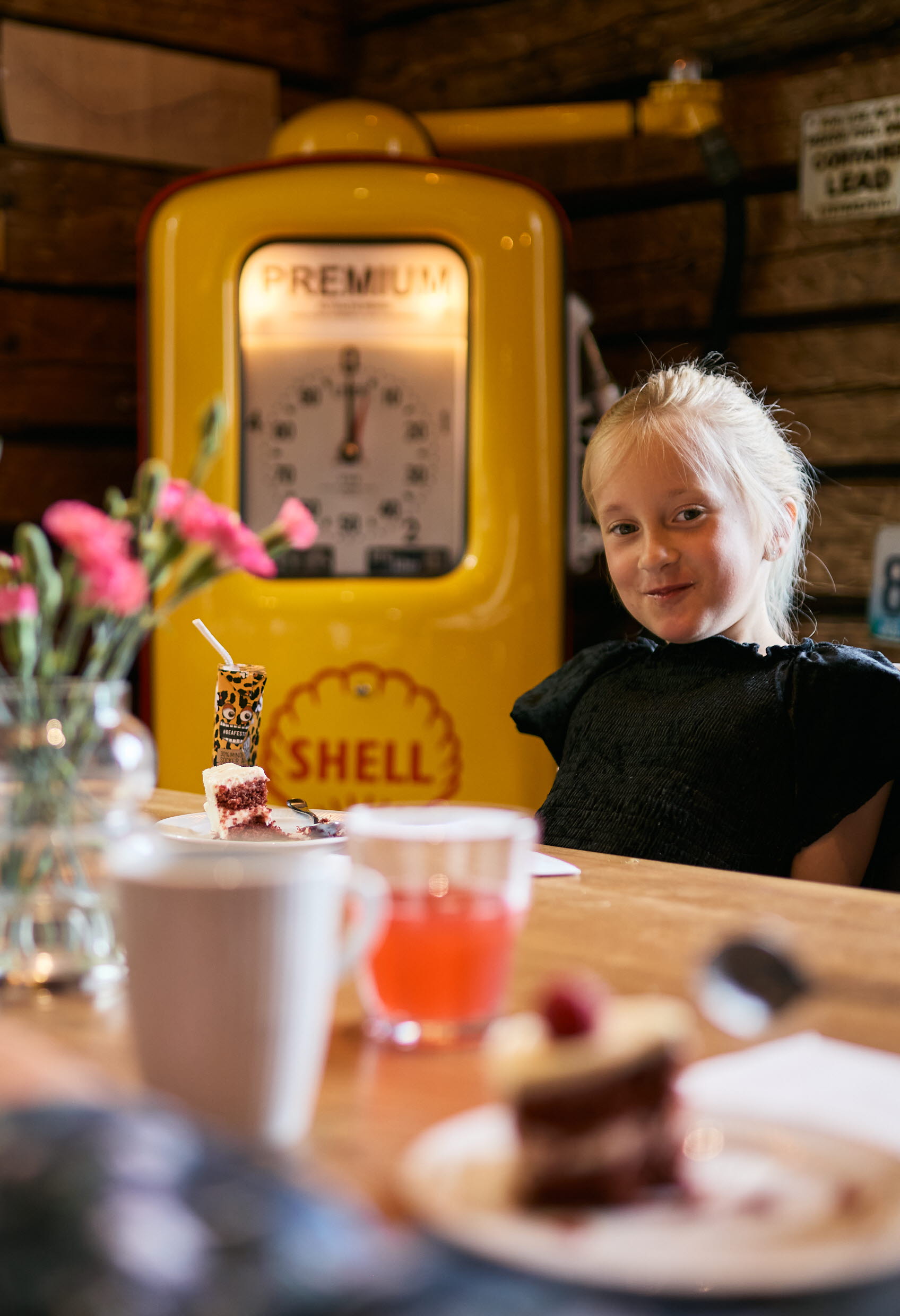 Familj äter och fikar runt ett bord på restaurang.