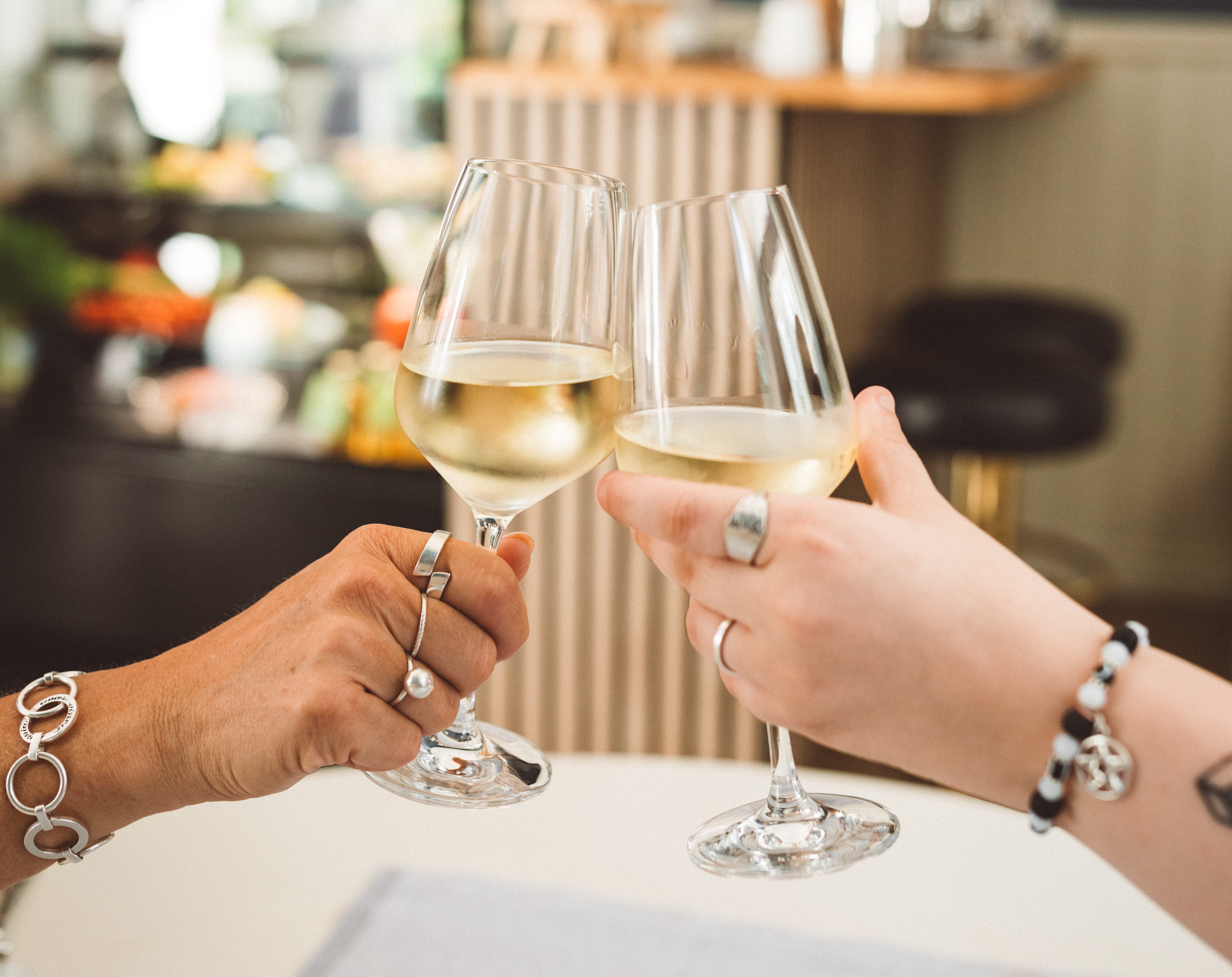 Två människor skålar i bubbel vid ett dukat bord.