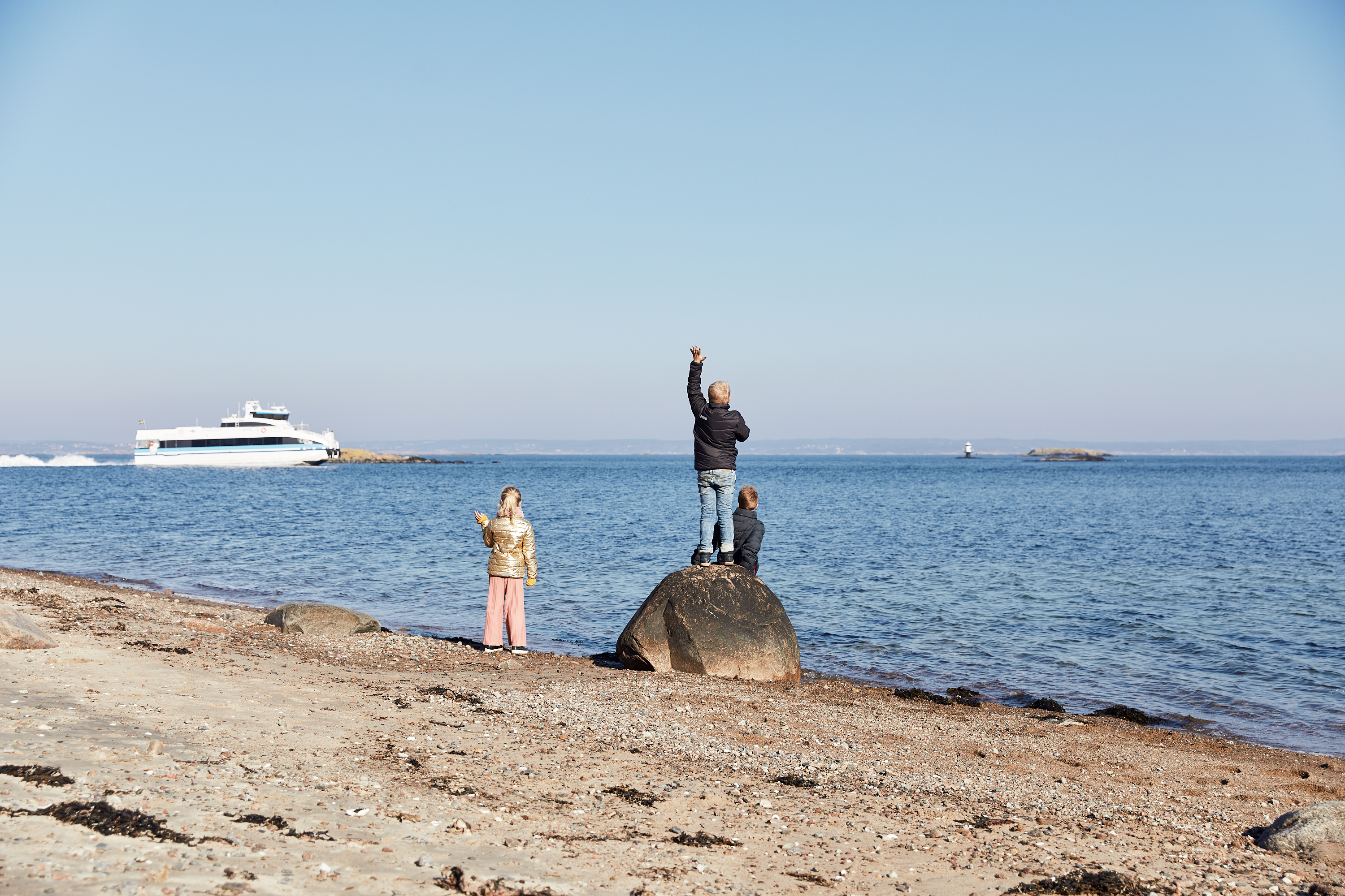 barn vinkar till en färja på Vrångö