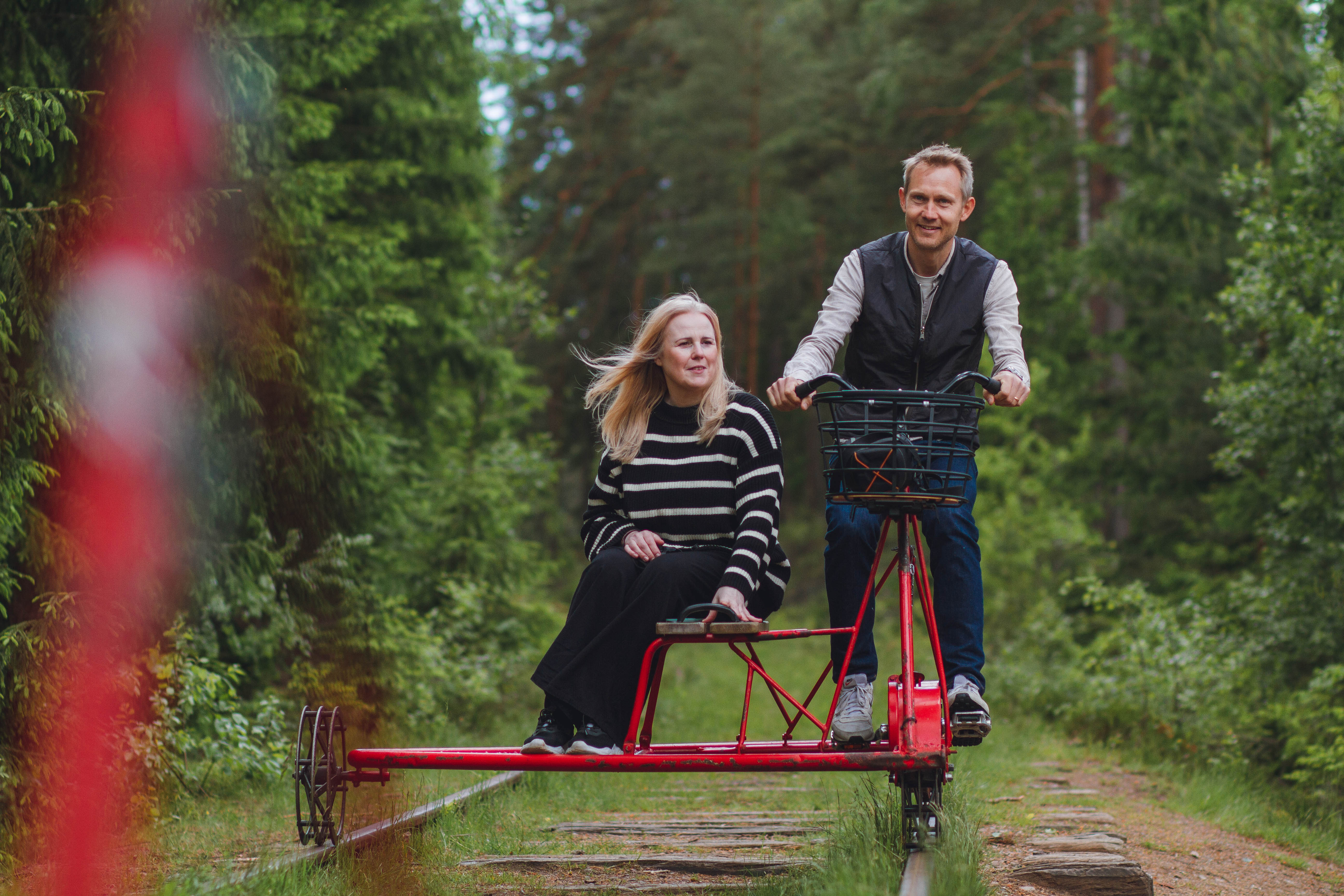 Two people on a railway push trolley.