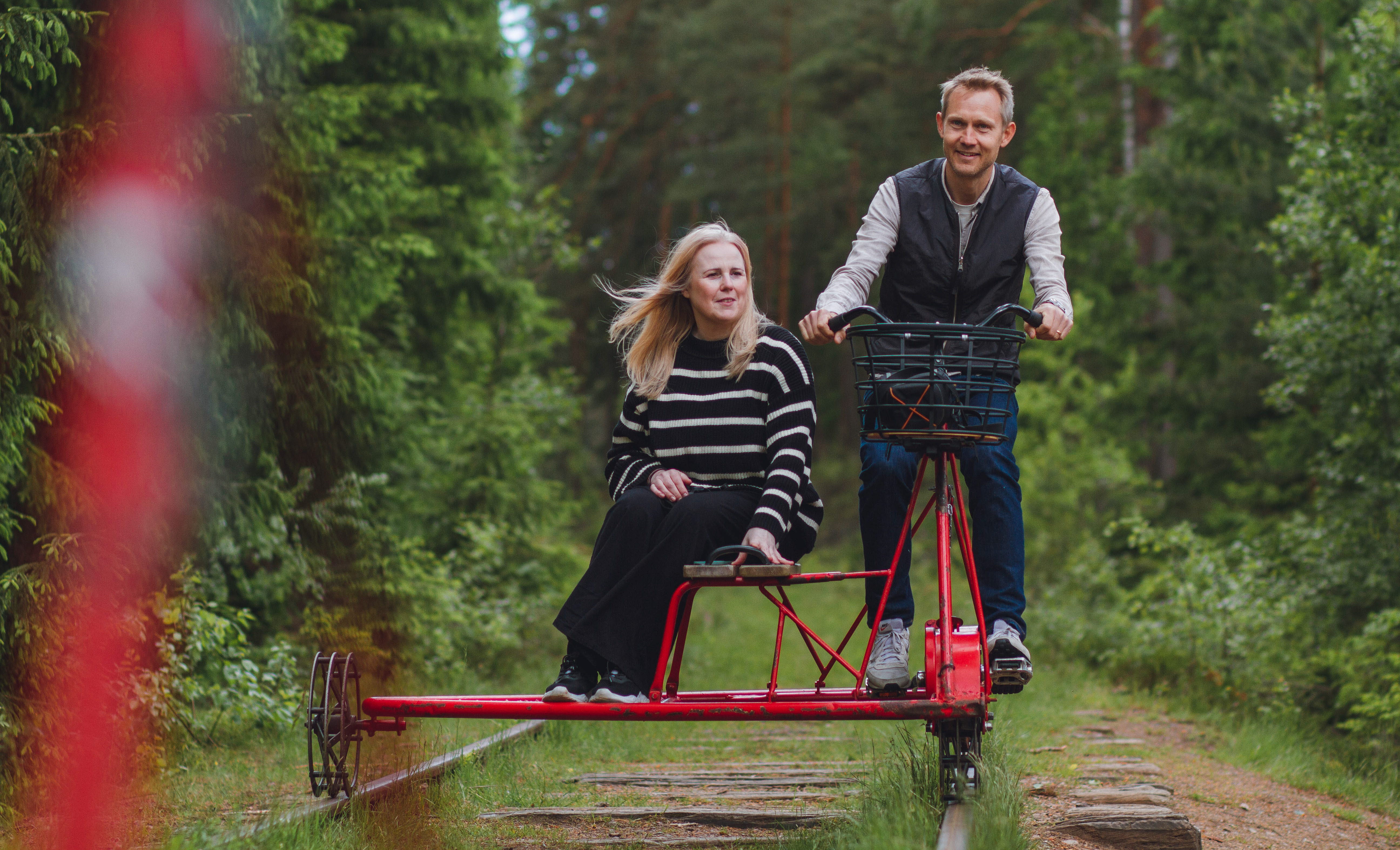 Två personer cyklar dressin.