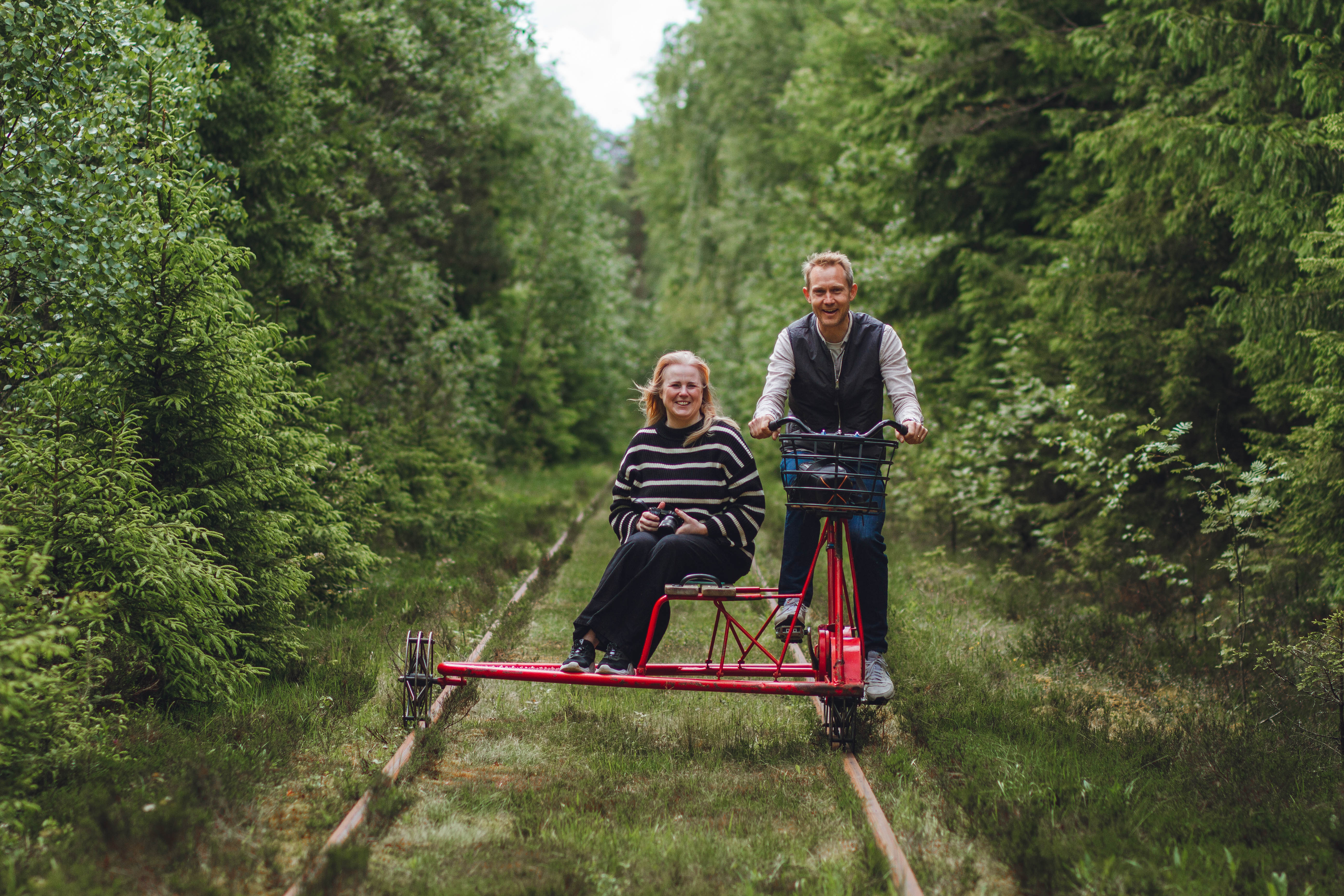 Two people on a railway push trolley.