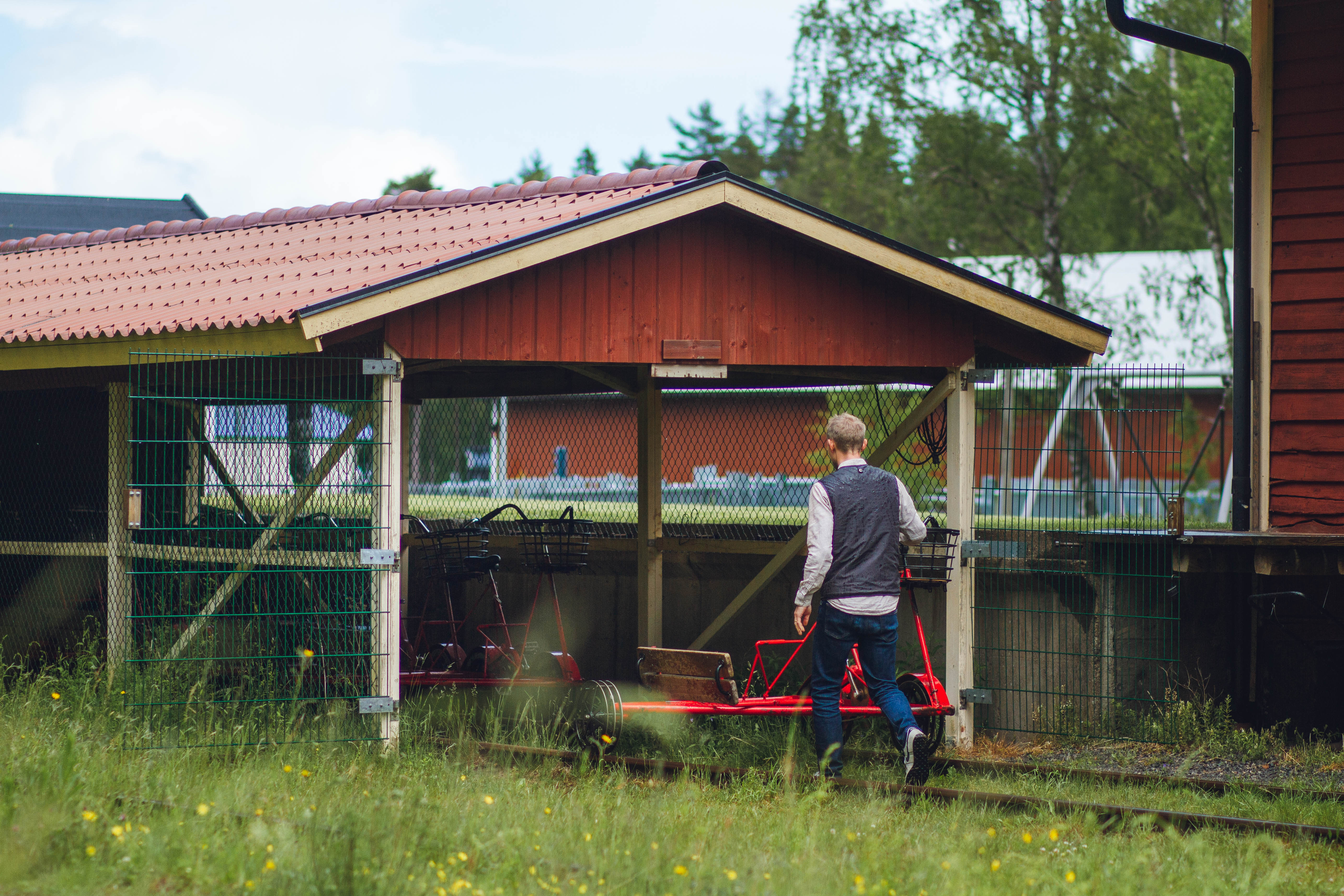 Man on is way towards a railway push trolley.