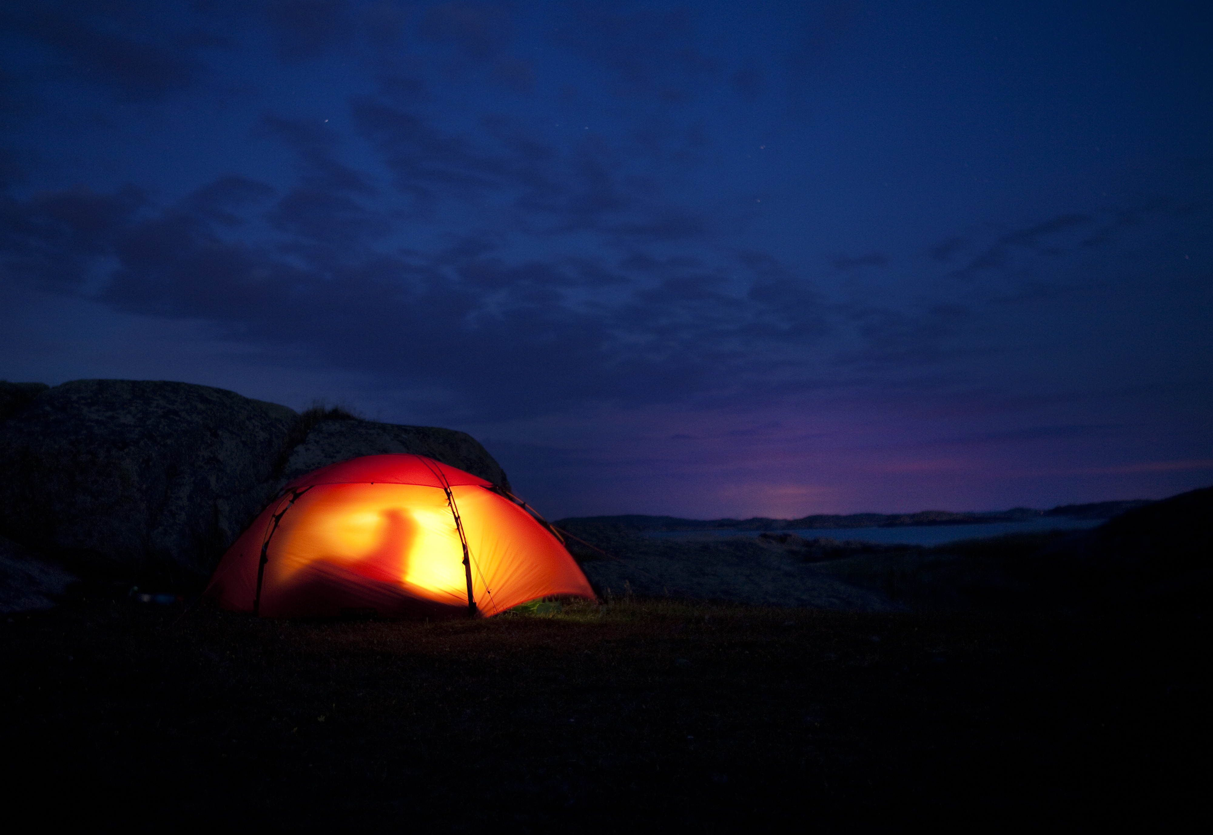 Upplyst tält på ö i sommarnatten