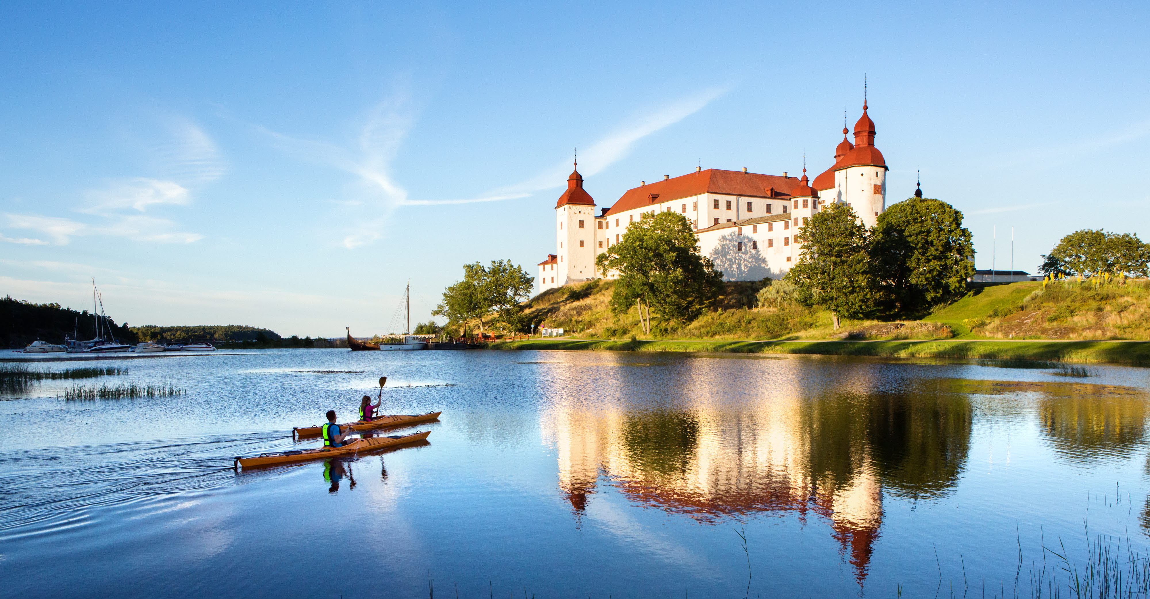 Par paddlar kajak utanför Läckö Slott