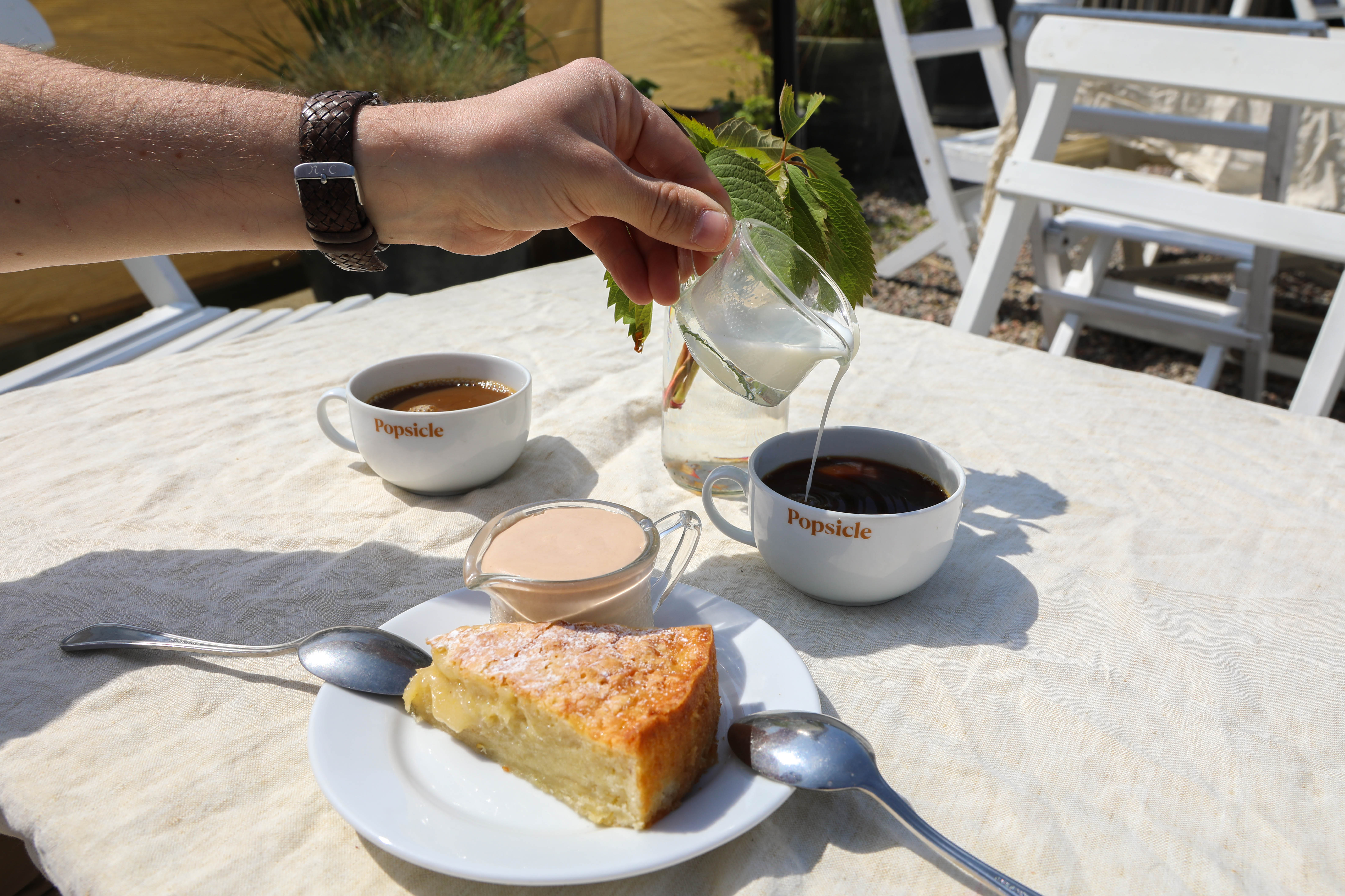 Fika uppdukad på ett bord i solen.