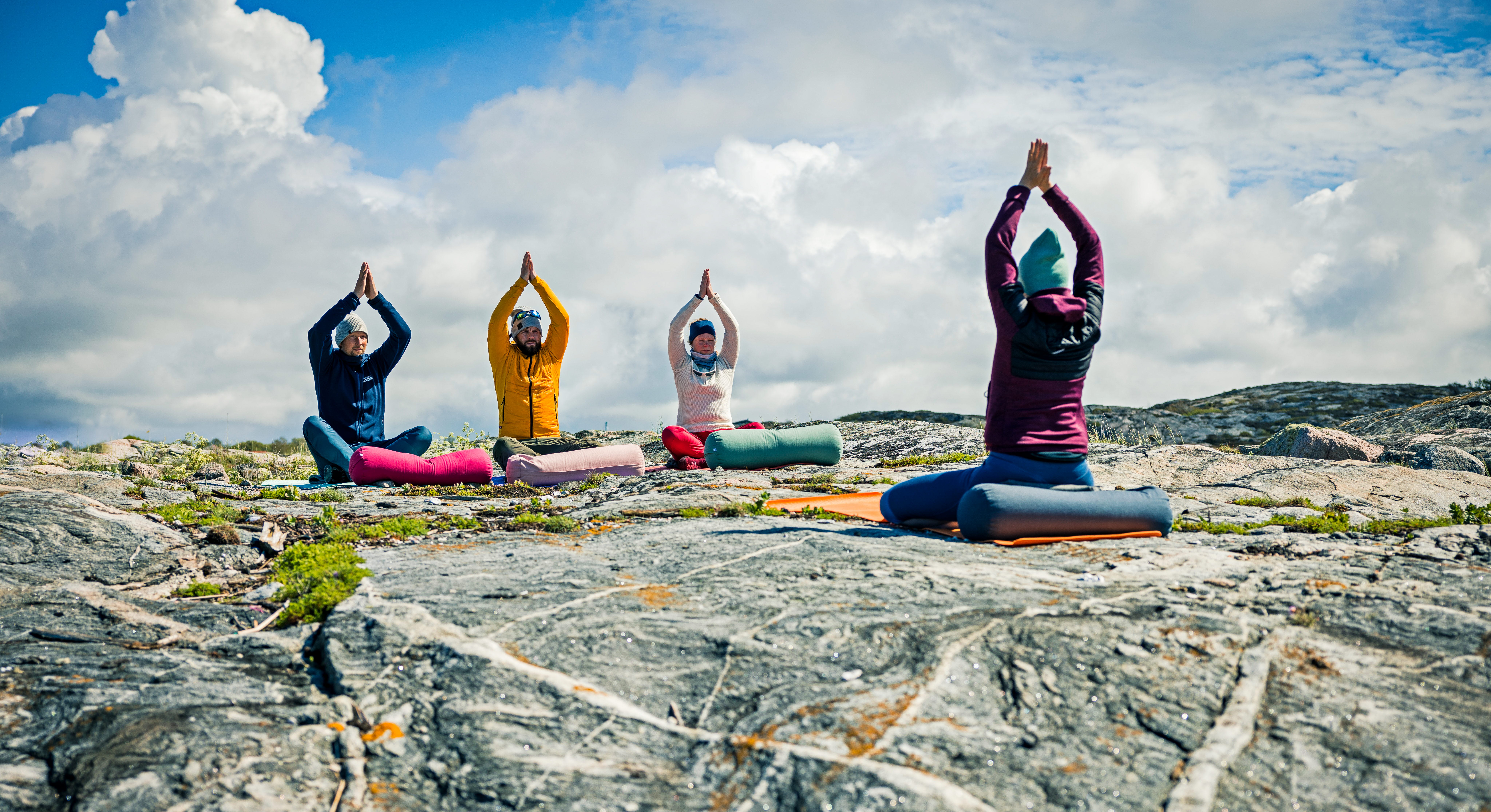En grupp människor som gör yoga utomhus på kusten.