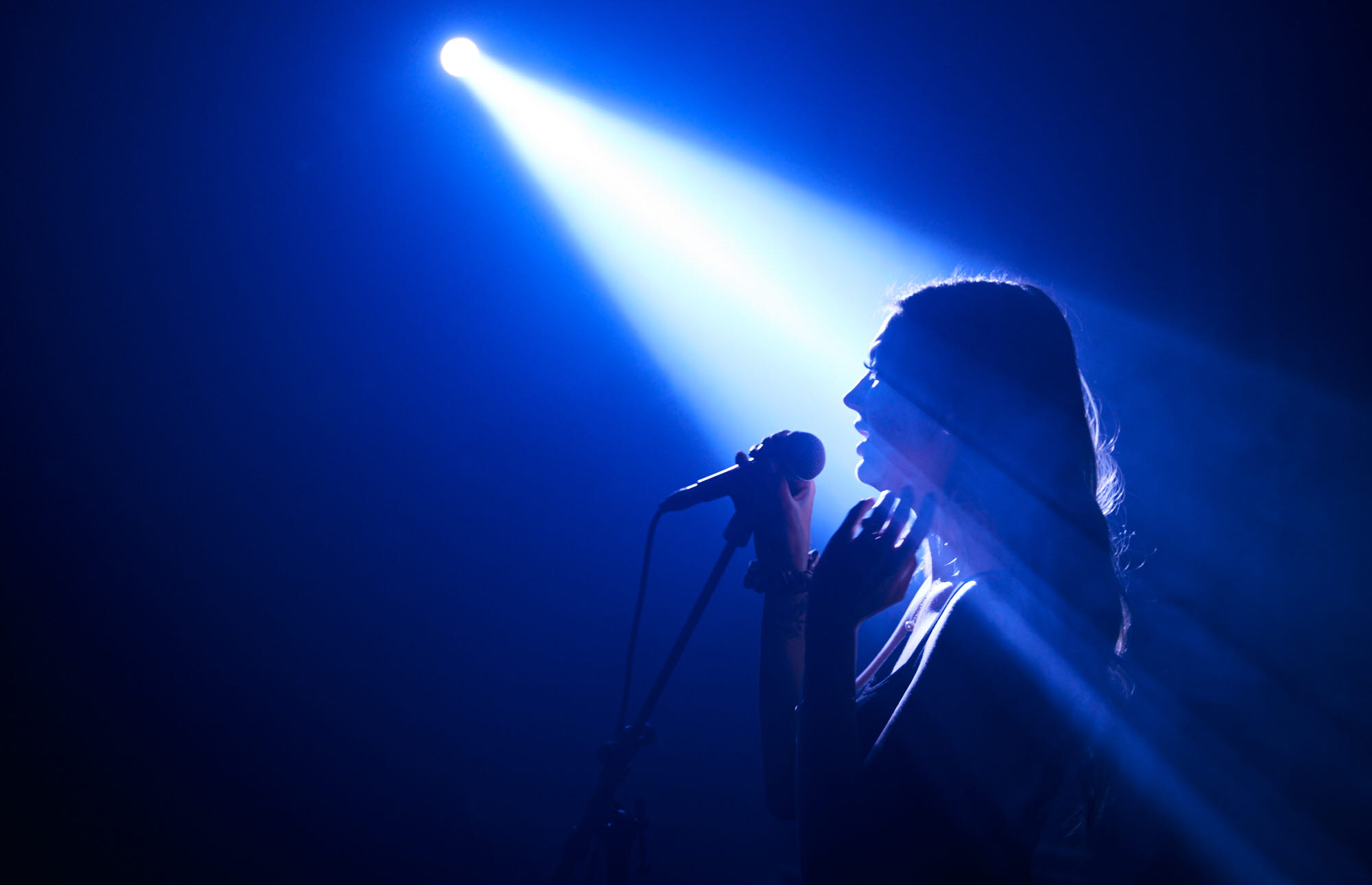 Woman singing on a stage.
