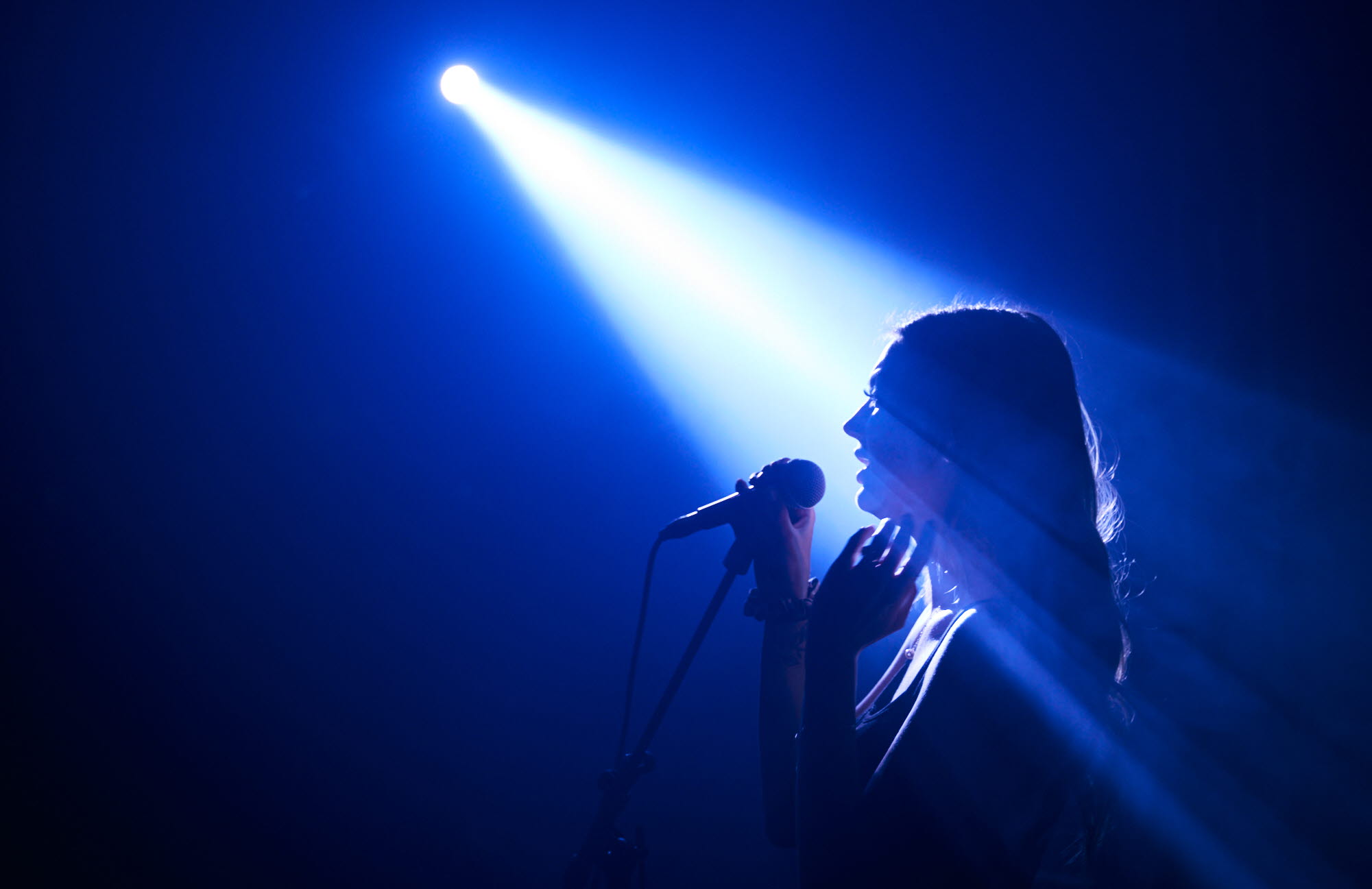 Woman singing on a stage.