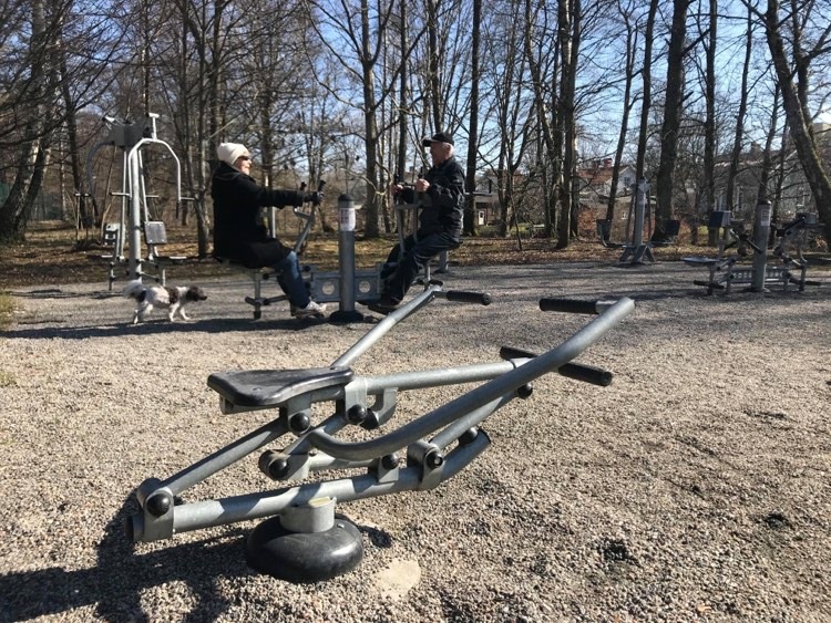 två pensionärer som tränar utegym. 