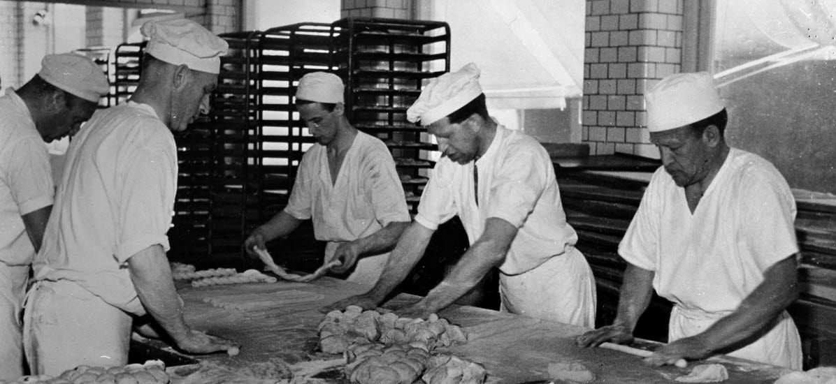 Uppslagning av kaffebröd. Fem bagare jobbar med degen.