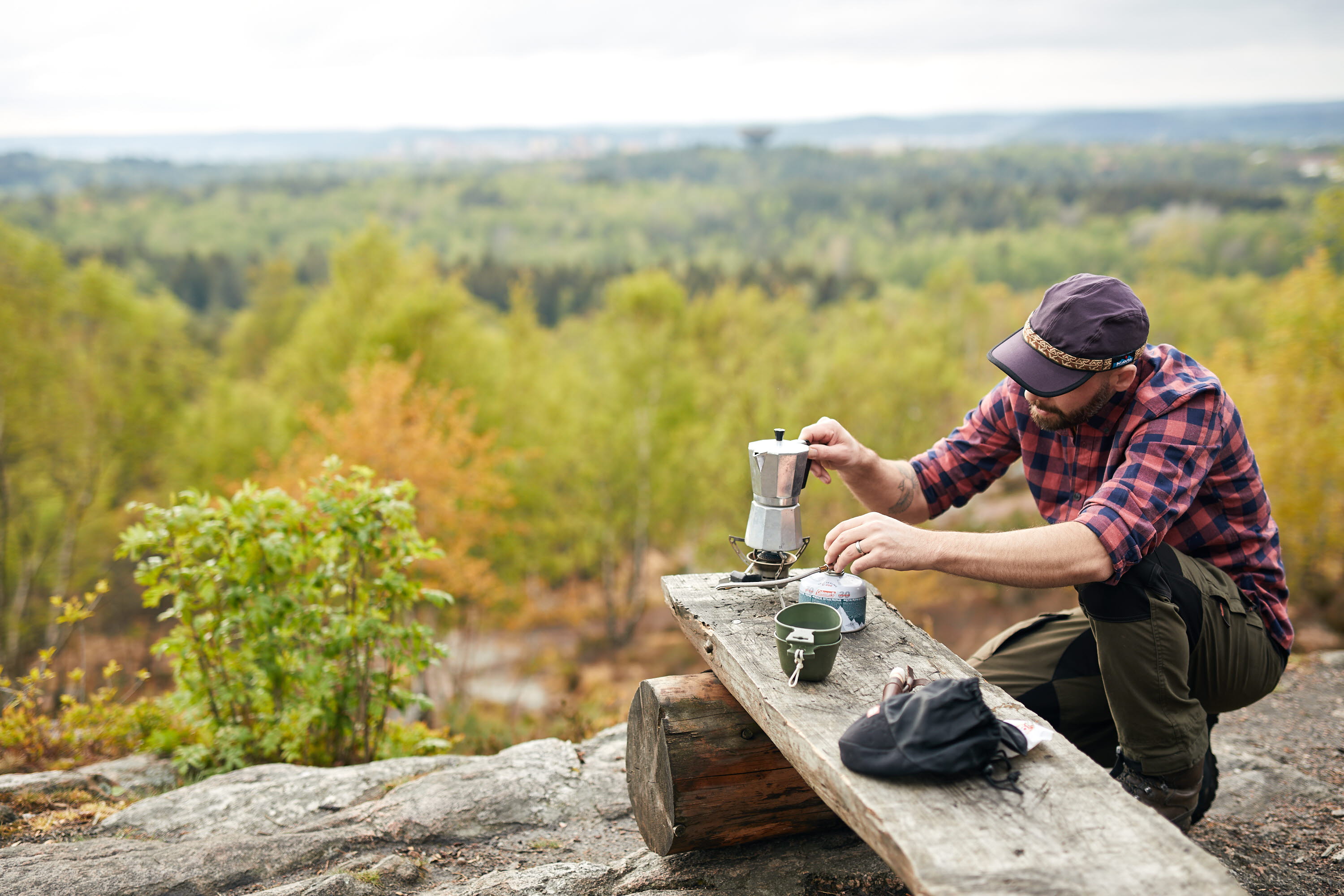 man sitting on a cliff with a view. 