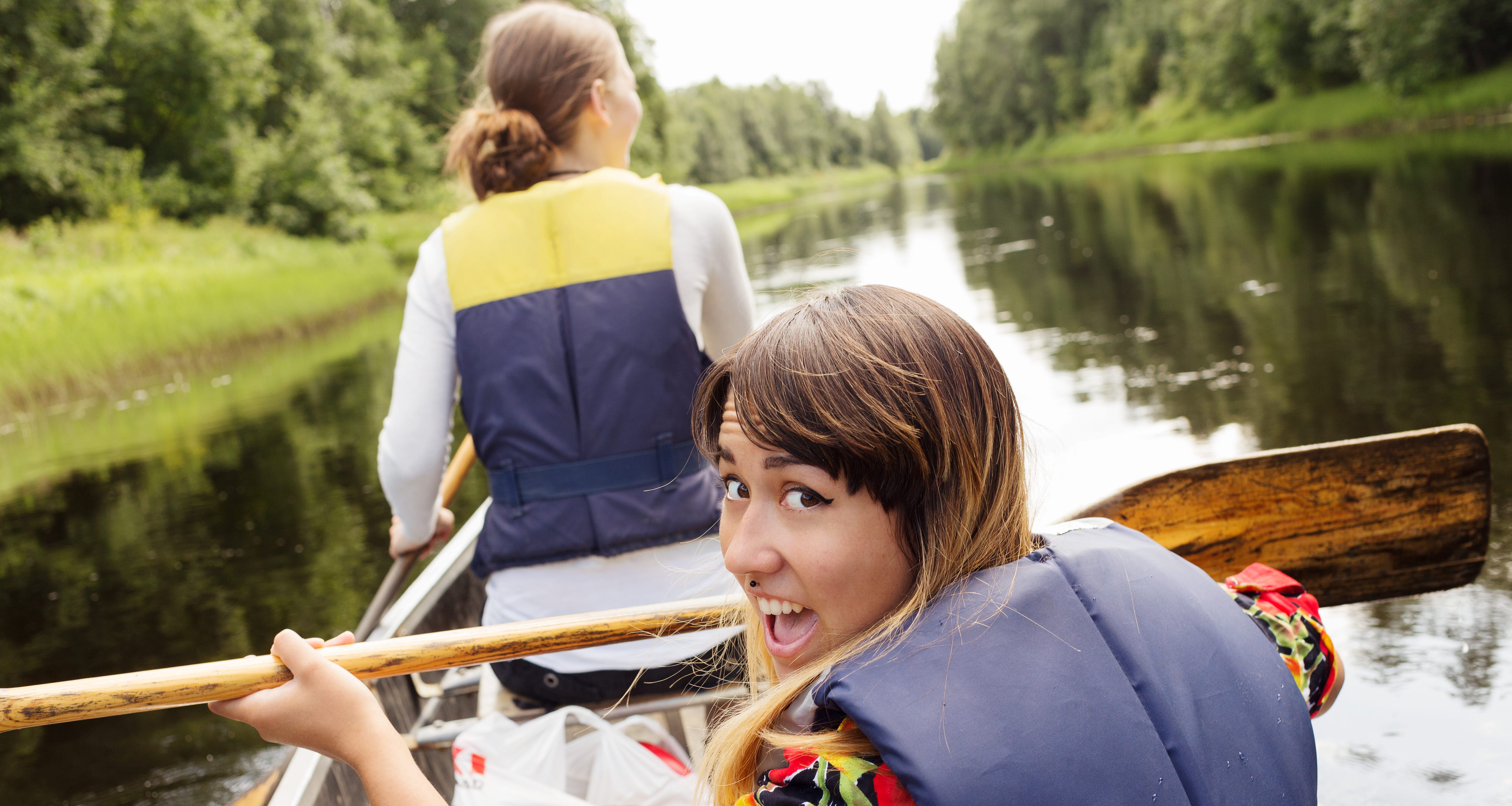 två tjejer som paddlar i en kanot. 