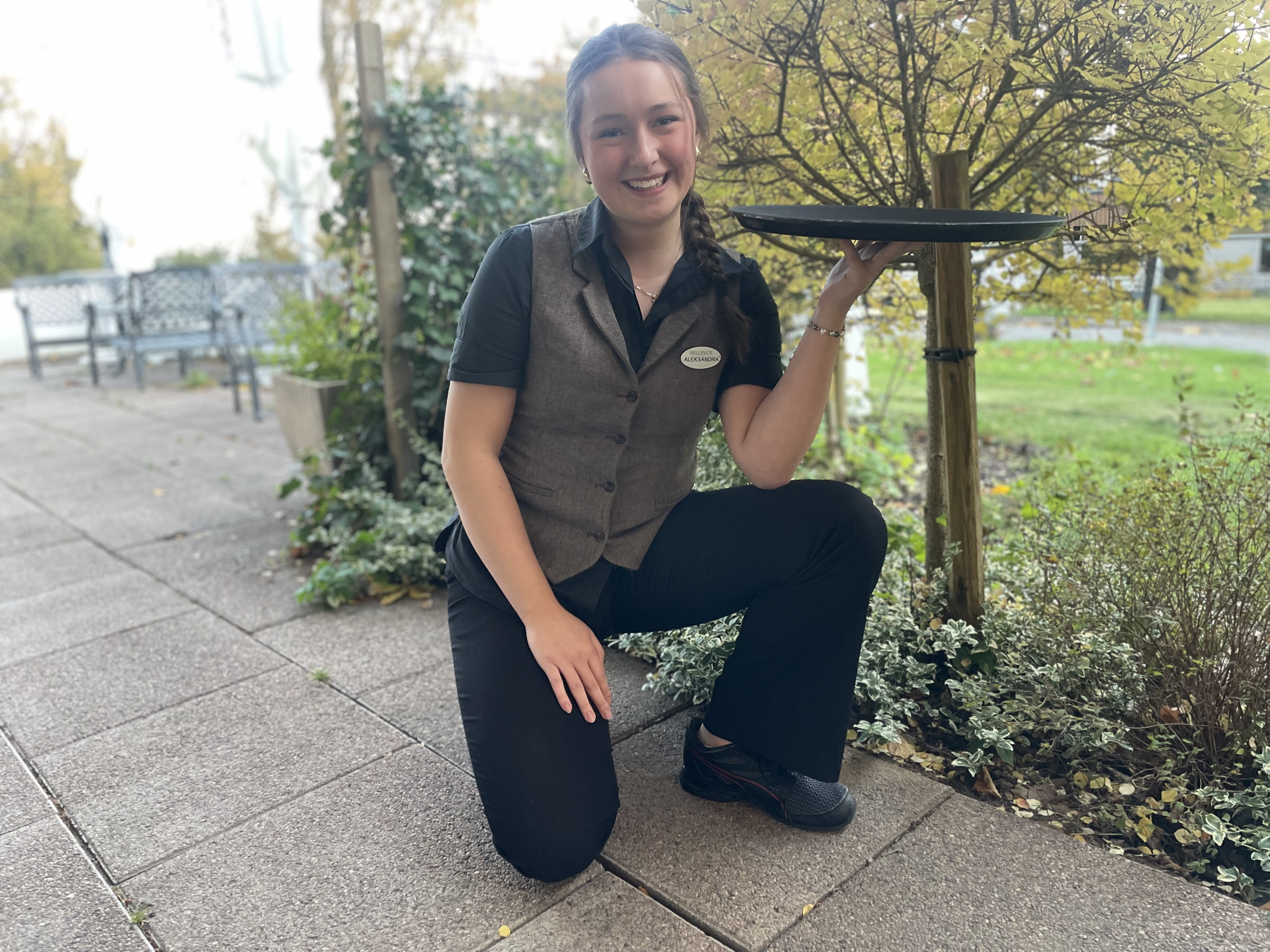 Servitris med en bricka i handen.