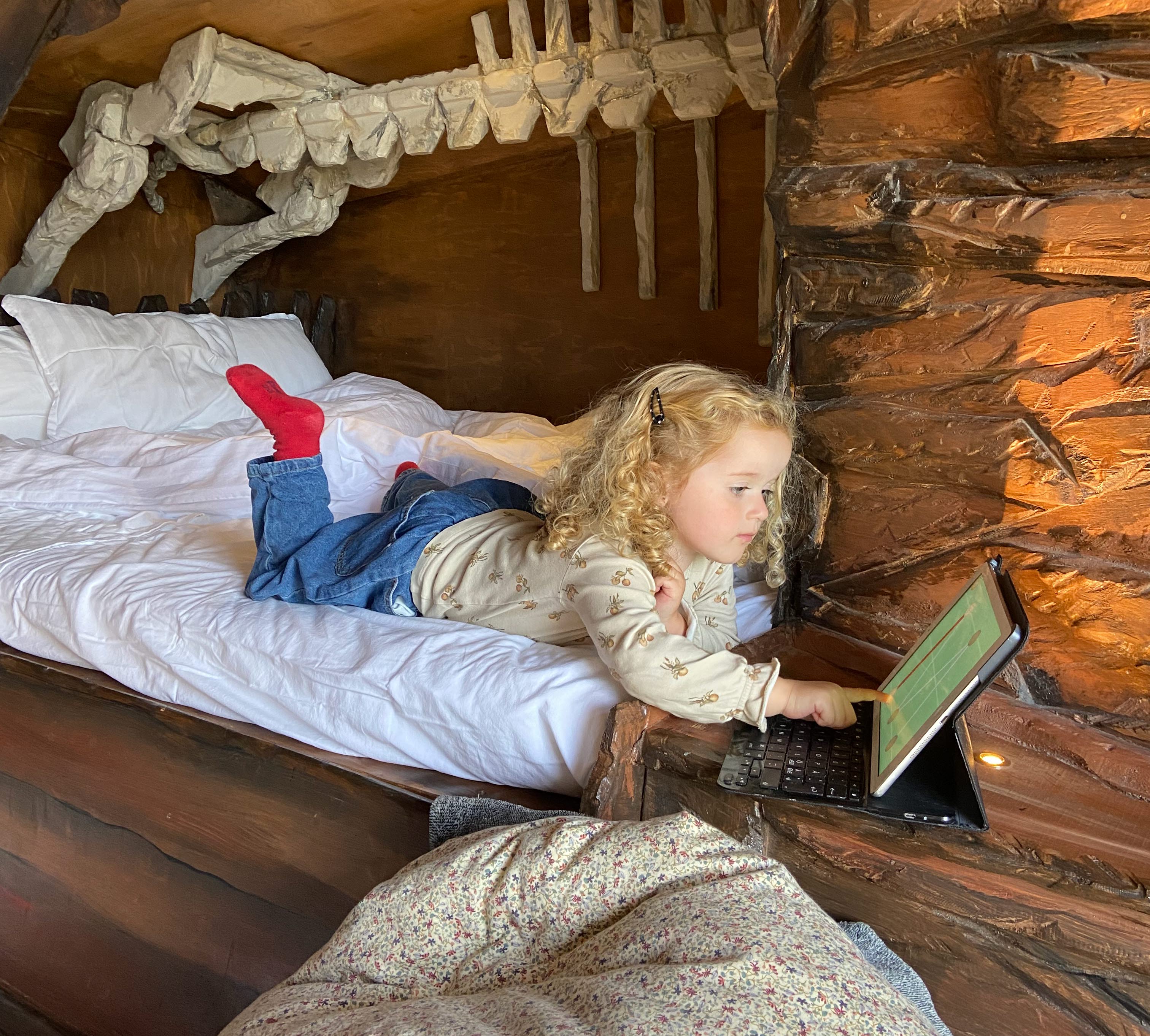 Girl lies on a made bed.