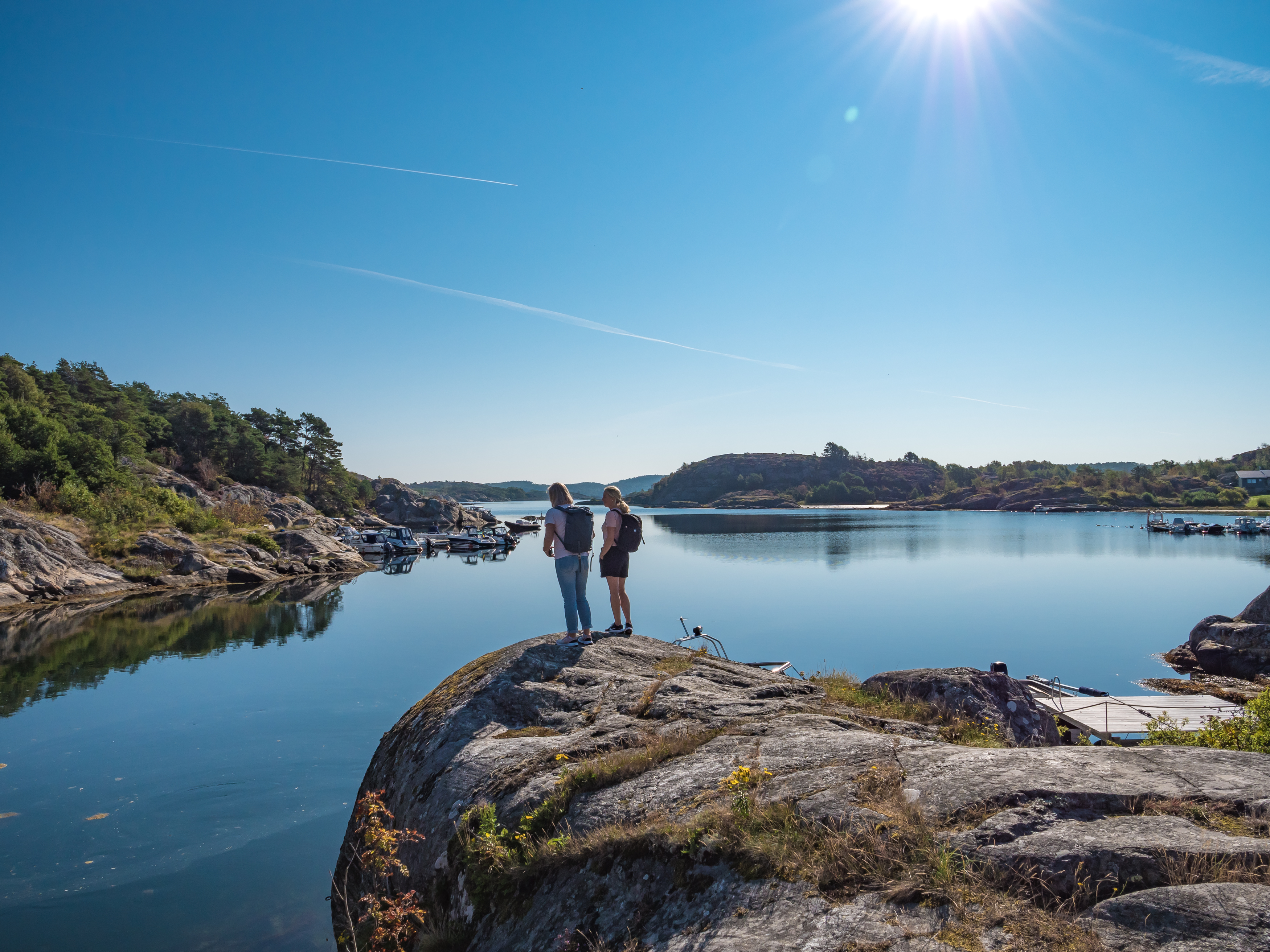 Coastal environment with rocks, blue sky and hikers.