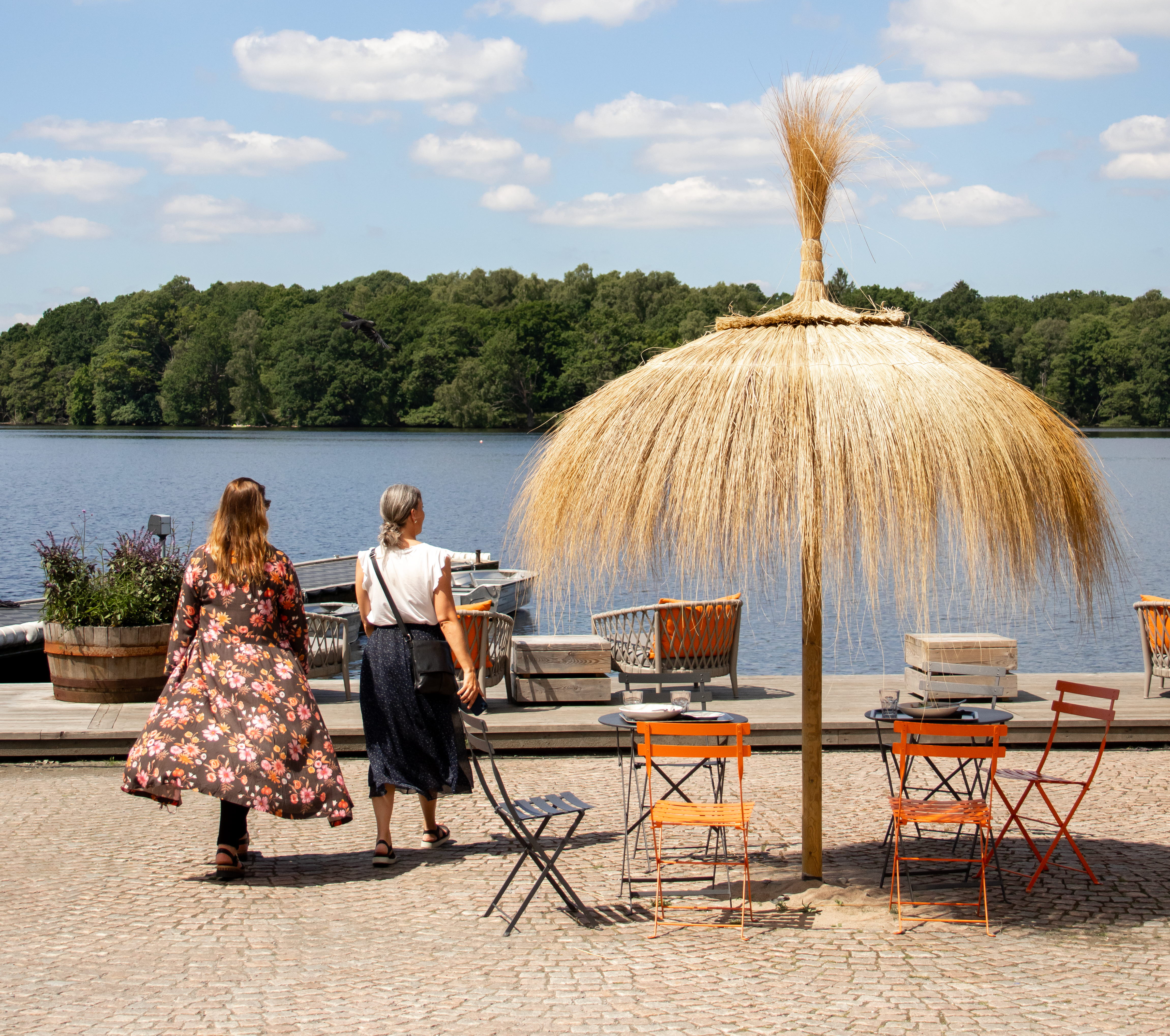Two women walking towards a lake.