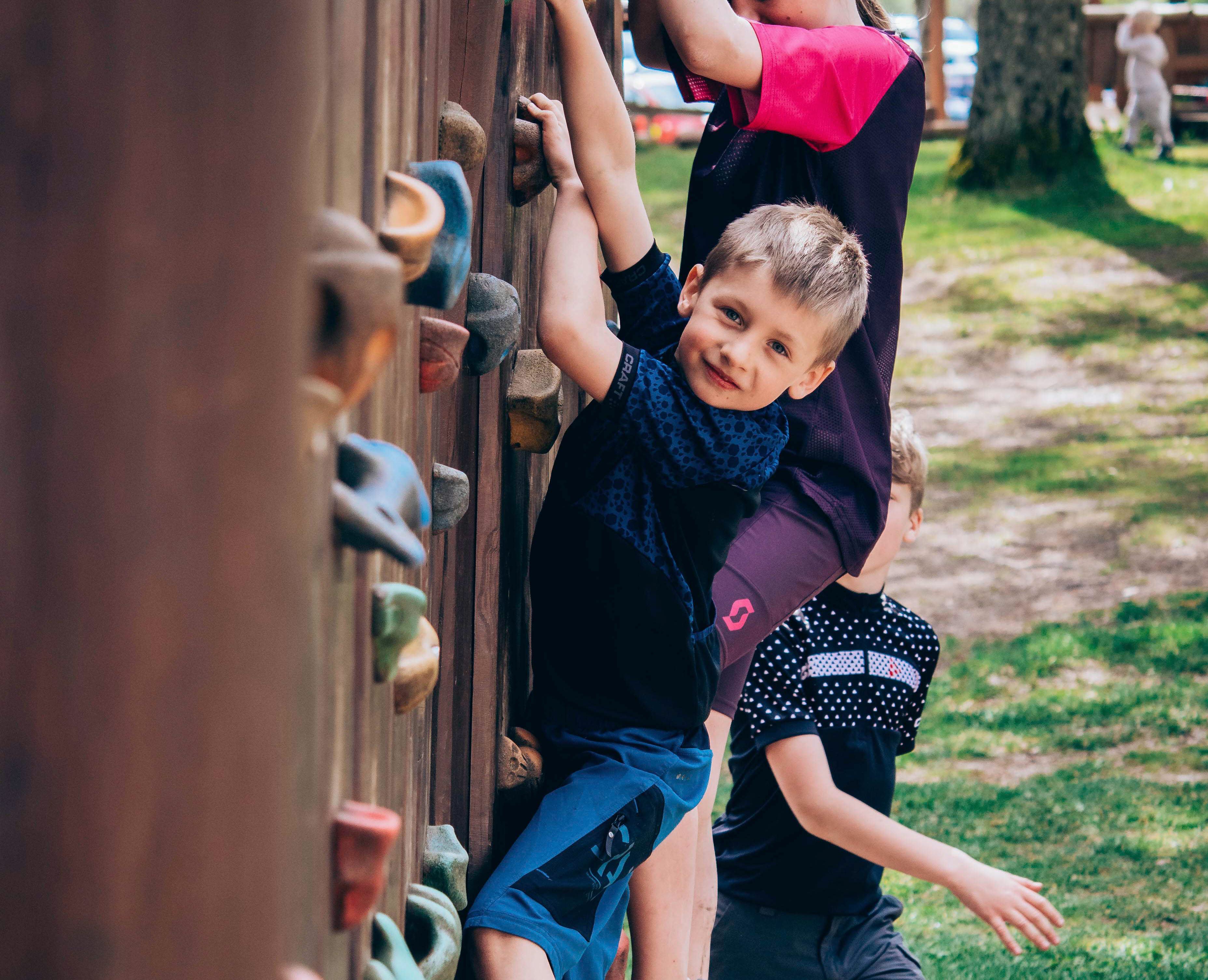 Glad kille som klättrar på klättervägg