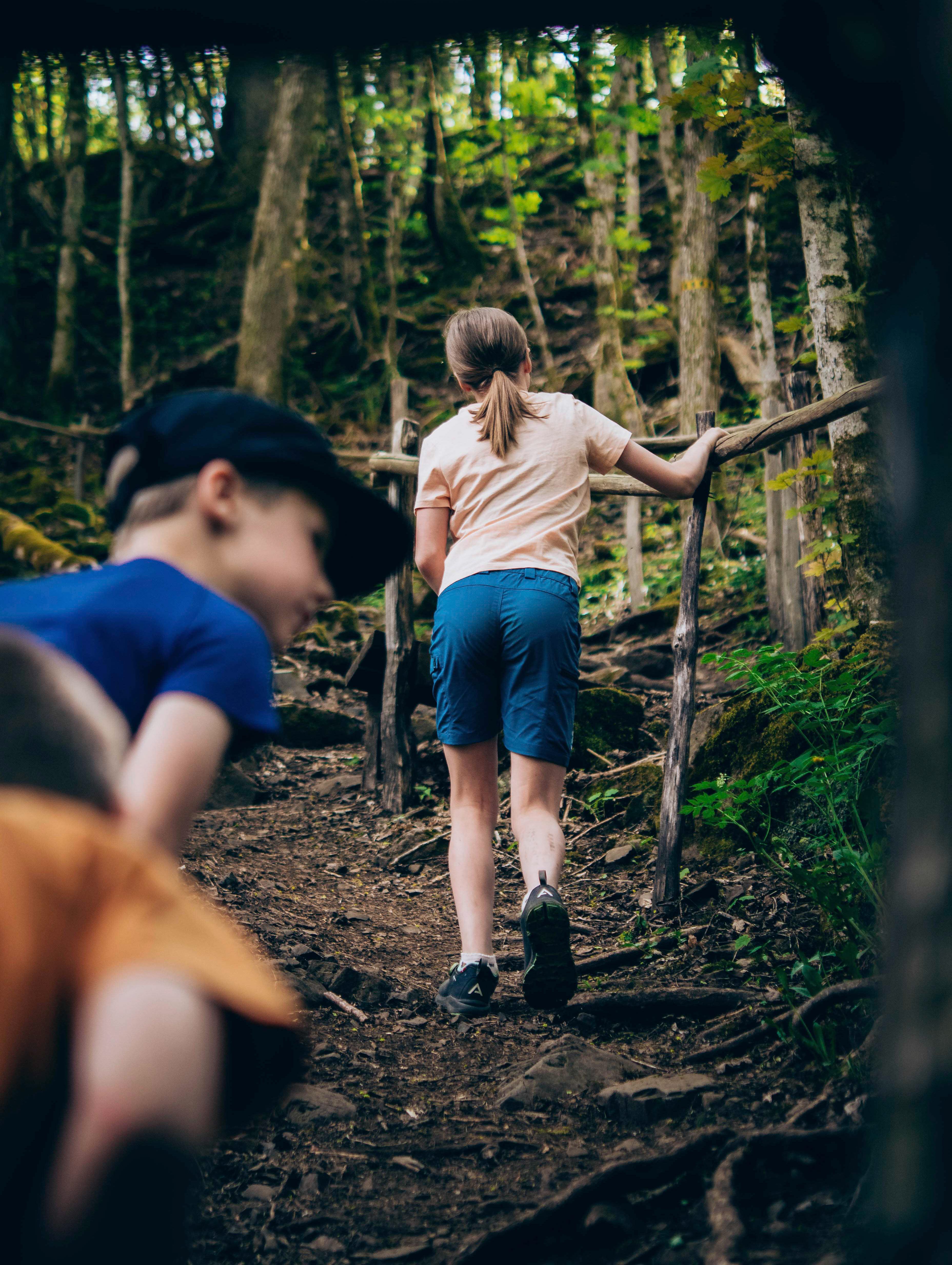 Barn som går uppgör brant stig i skogen