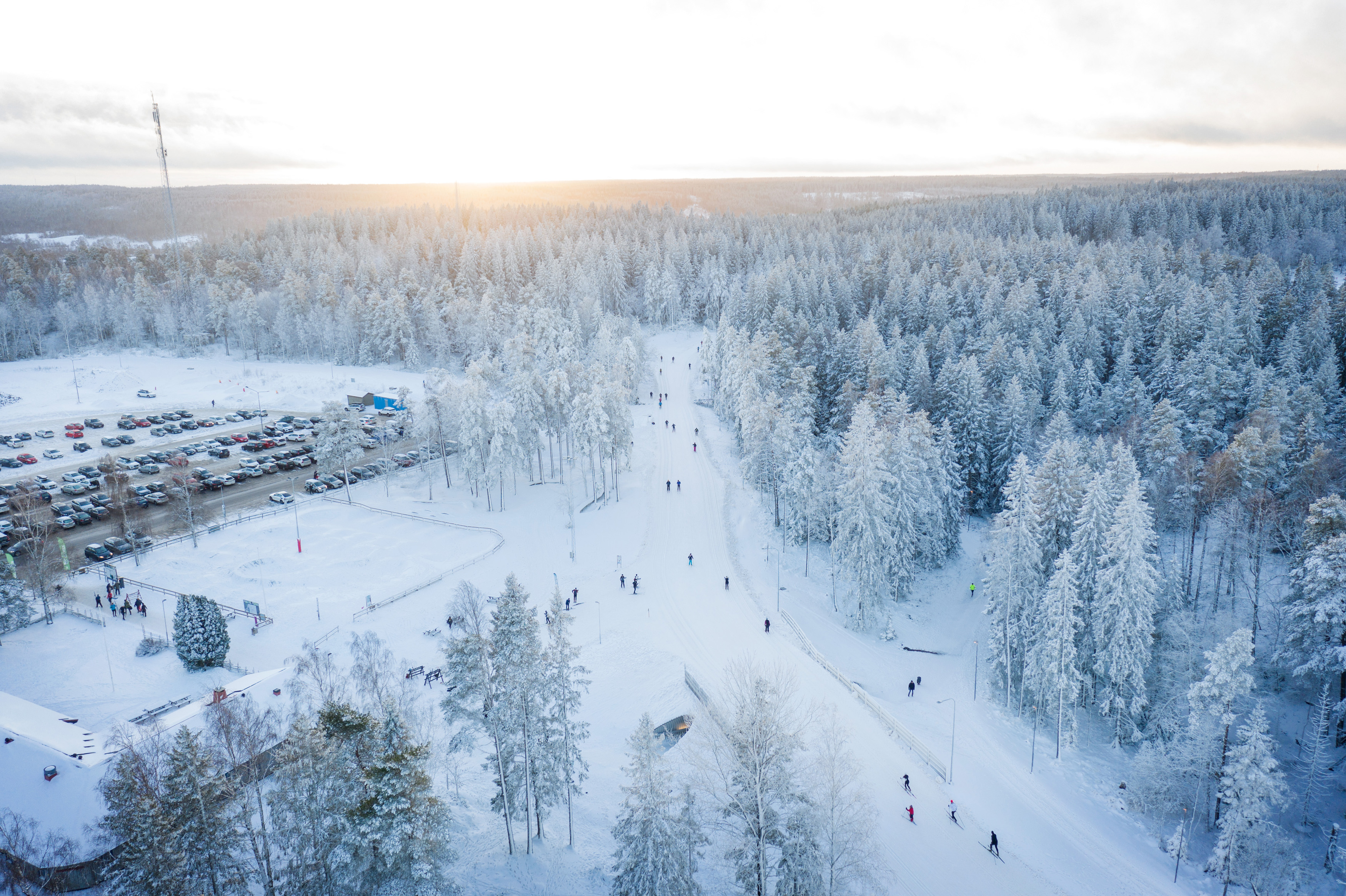 Drönarfoto över skidspåren en vinterdag på Billingen Skövde, i kanten syns parkeringen. 