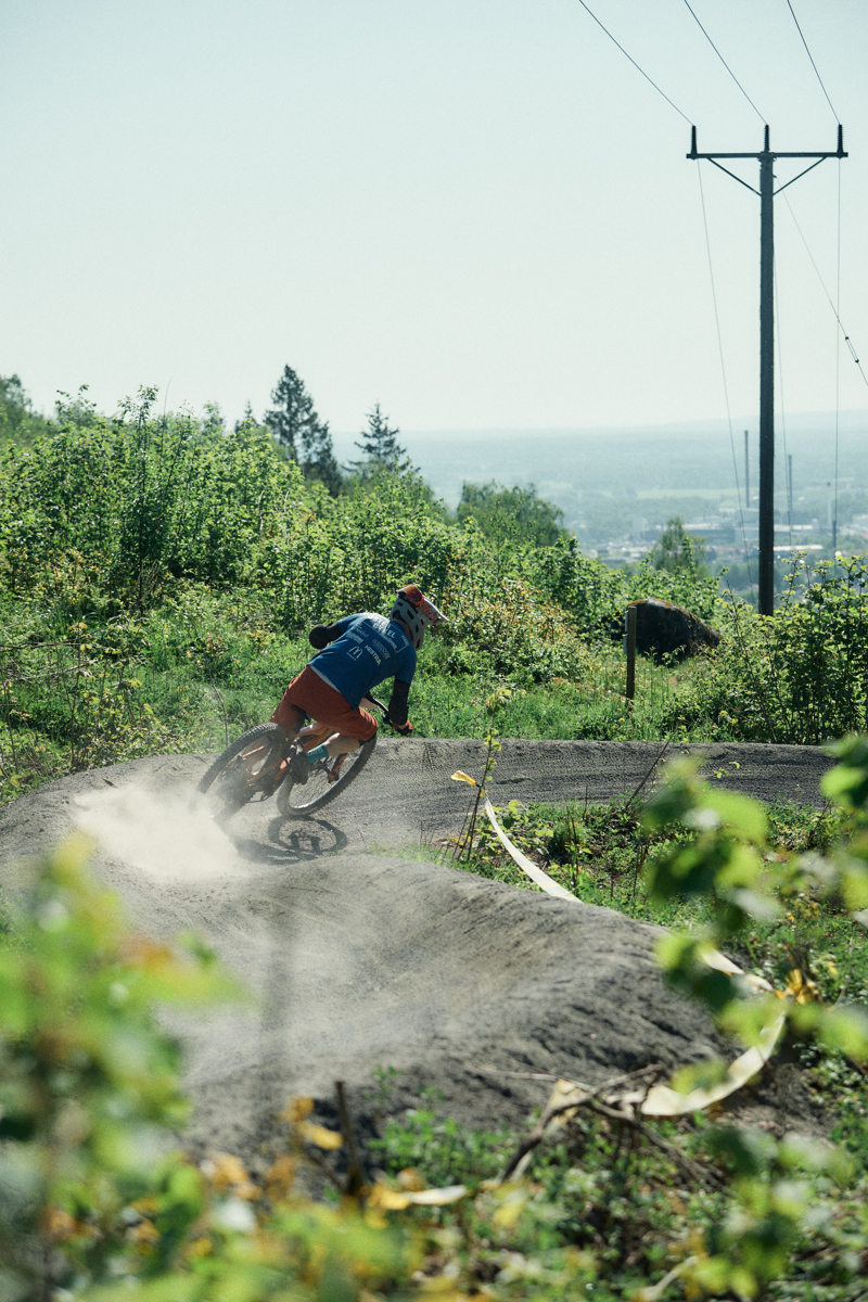 En person cyklar nedför en brant grusad cykelled