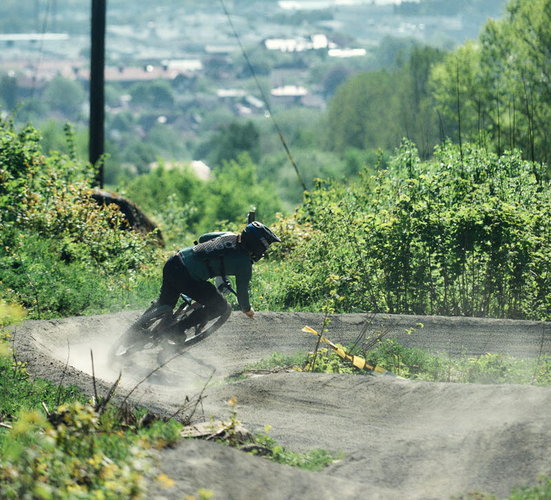 A person is riding down a steep gravel bike trail.