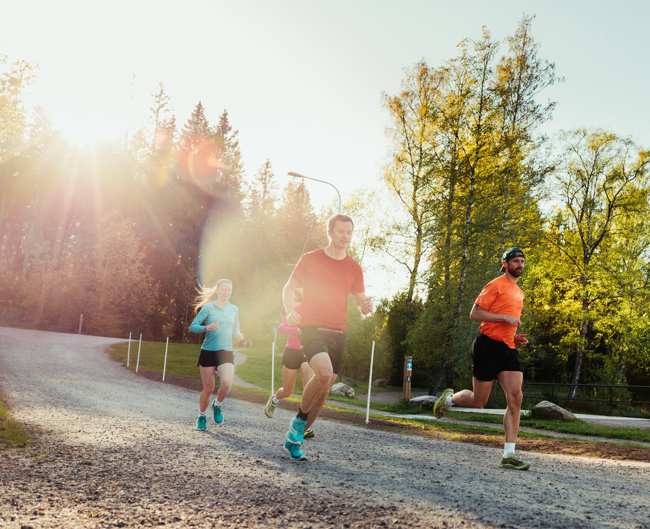 En grupp människor som springer längs en grusväg.