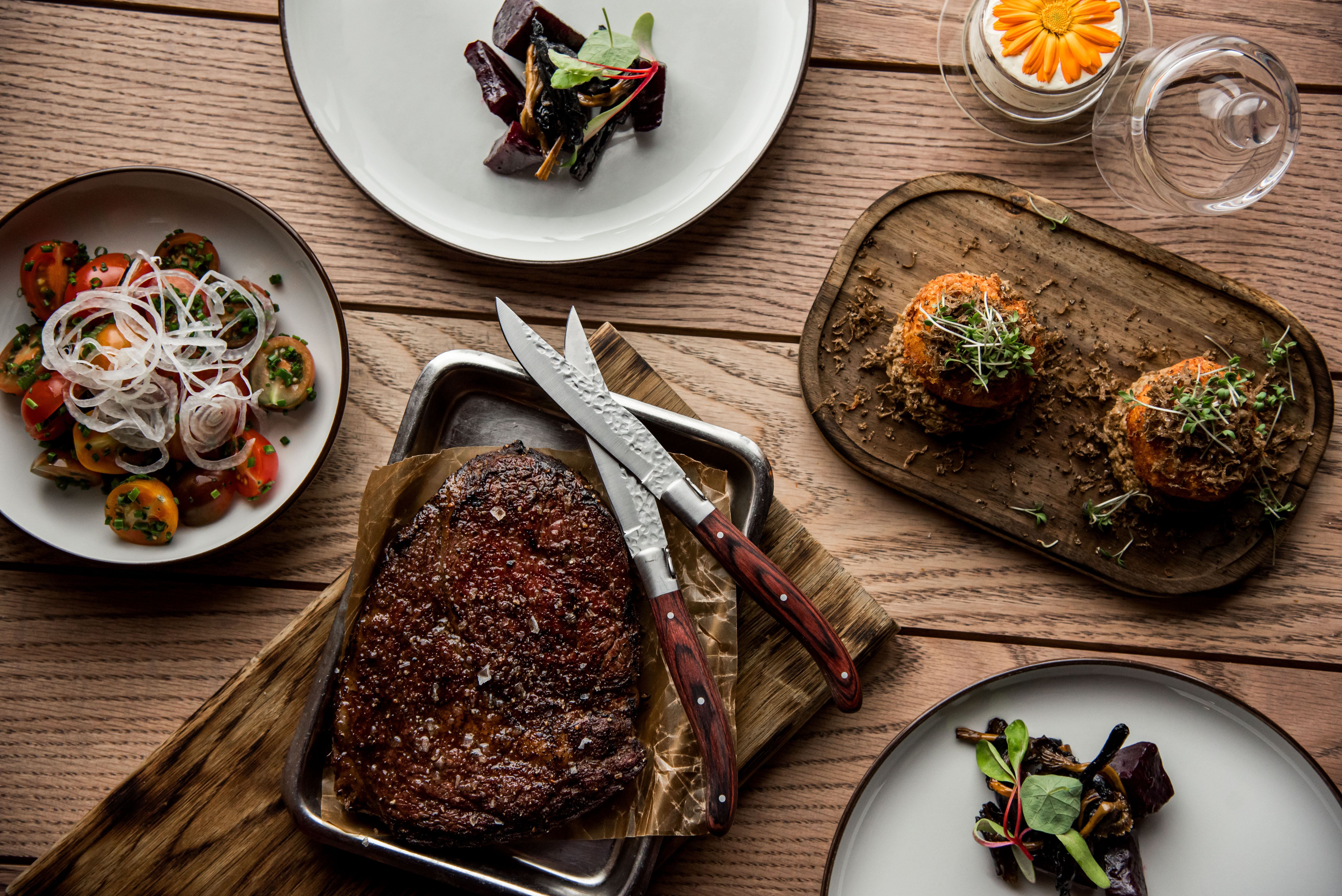 Flera tallrikar med små maträtter på ett träbord