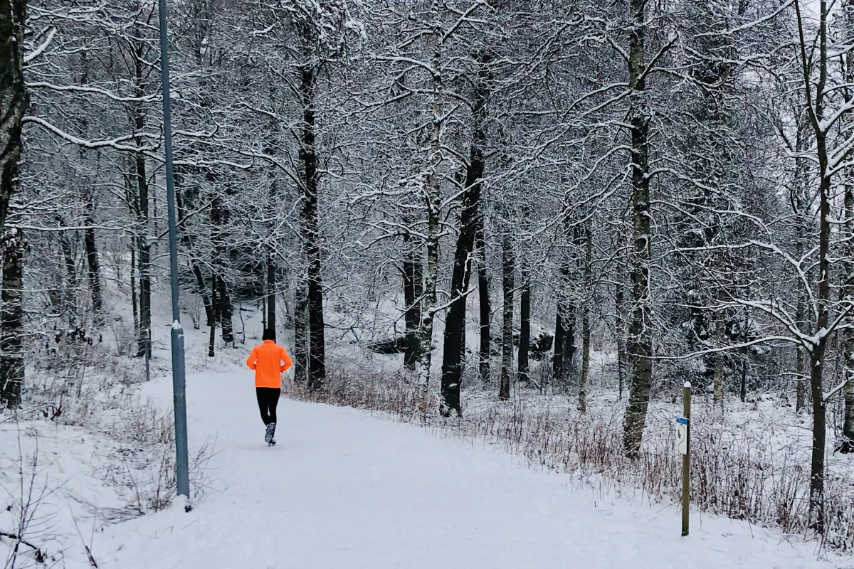 En person som springer längs en snötäckt stig.