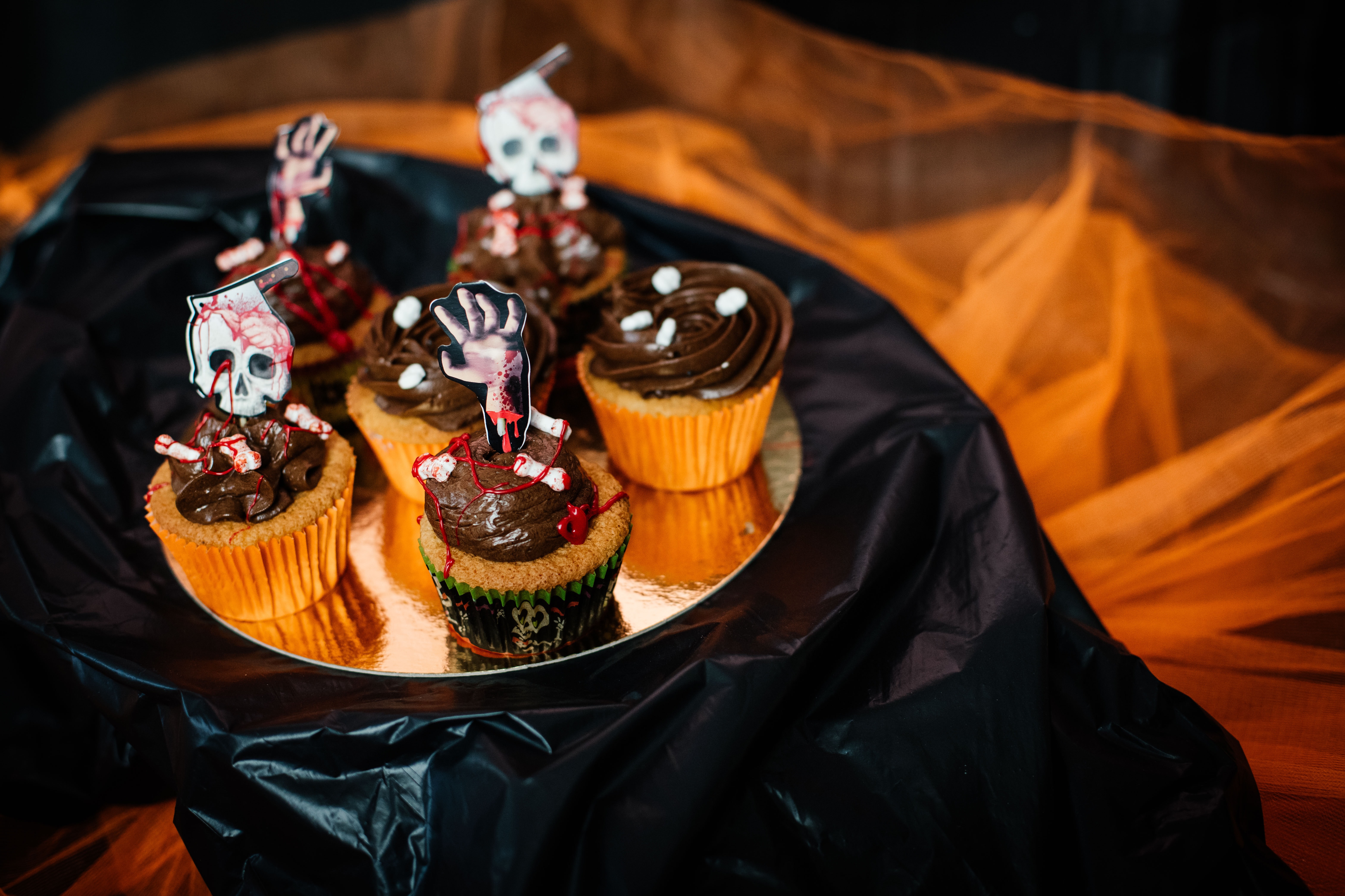 Bilden visar fem chokladmuffins som alla har fått halloween dekorationer