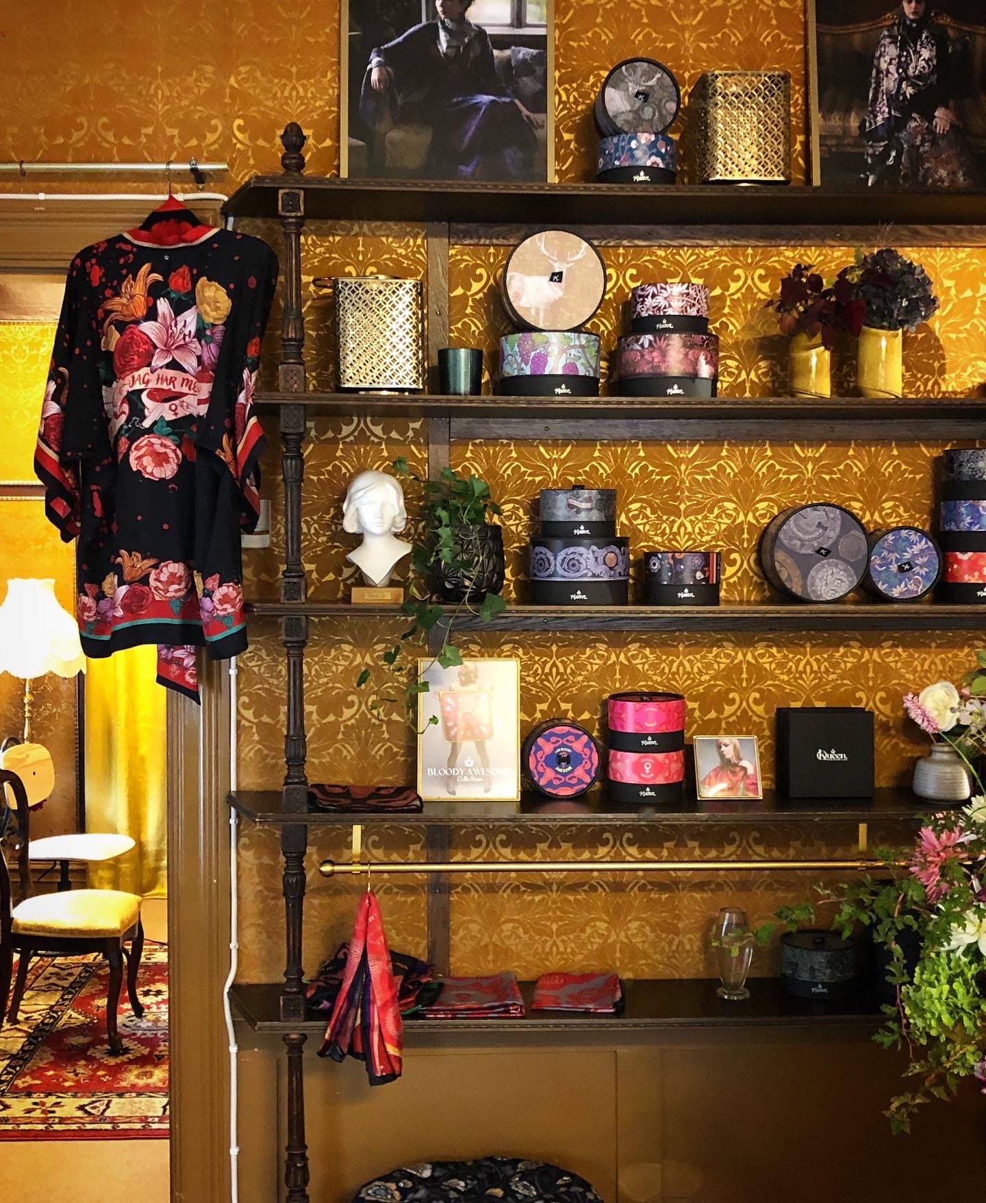 En vägg med färgglada lådor i en hylla och en kimono hängande på hyllan.