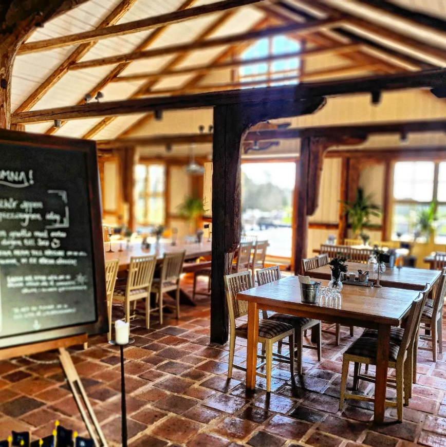 Inne i en restaurang med tegelgolv och träinredning.