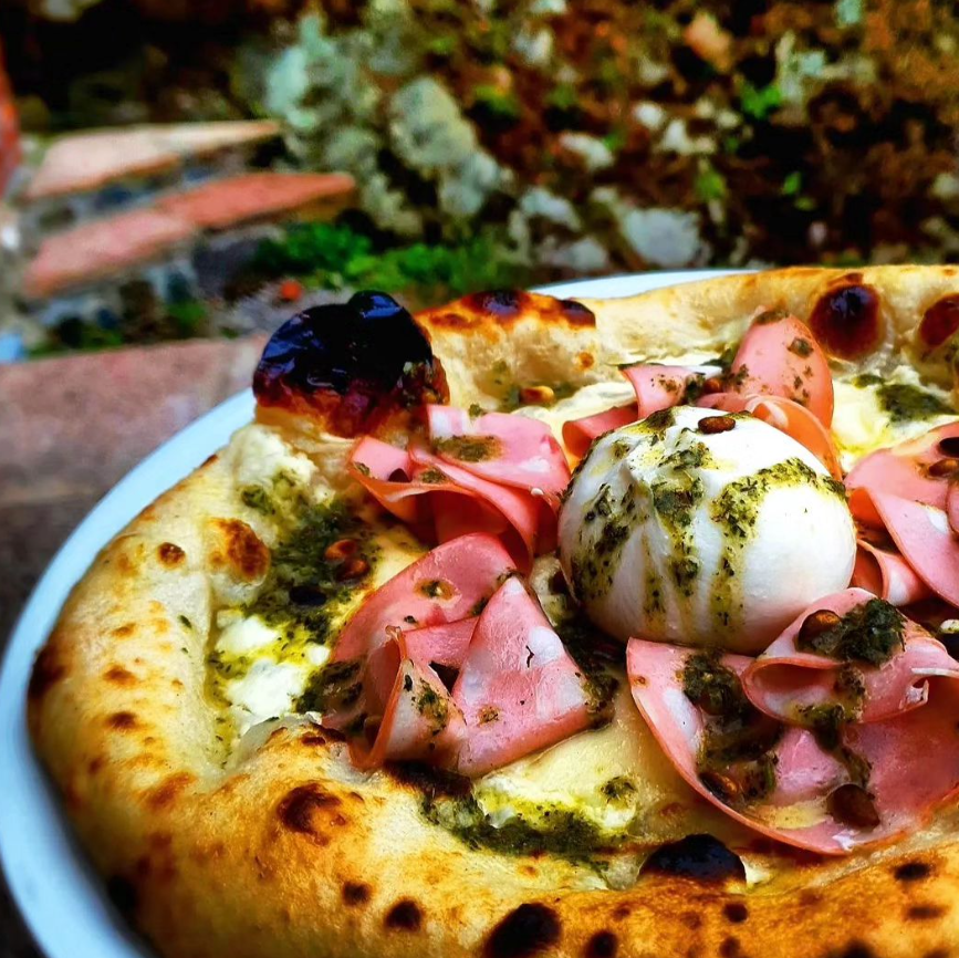 En pizza med skinka och mozarella.